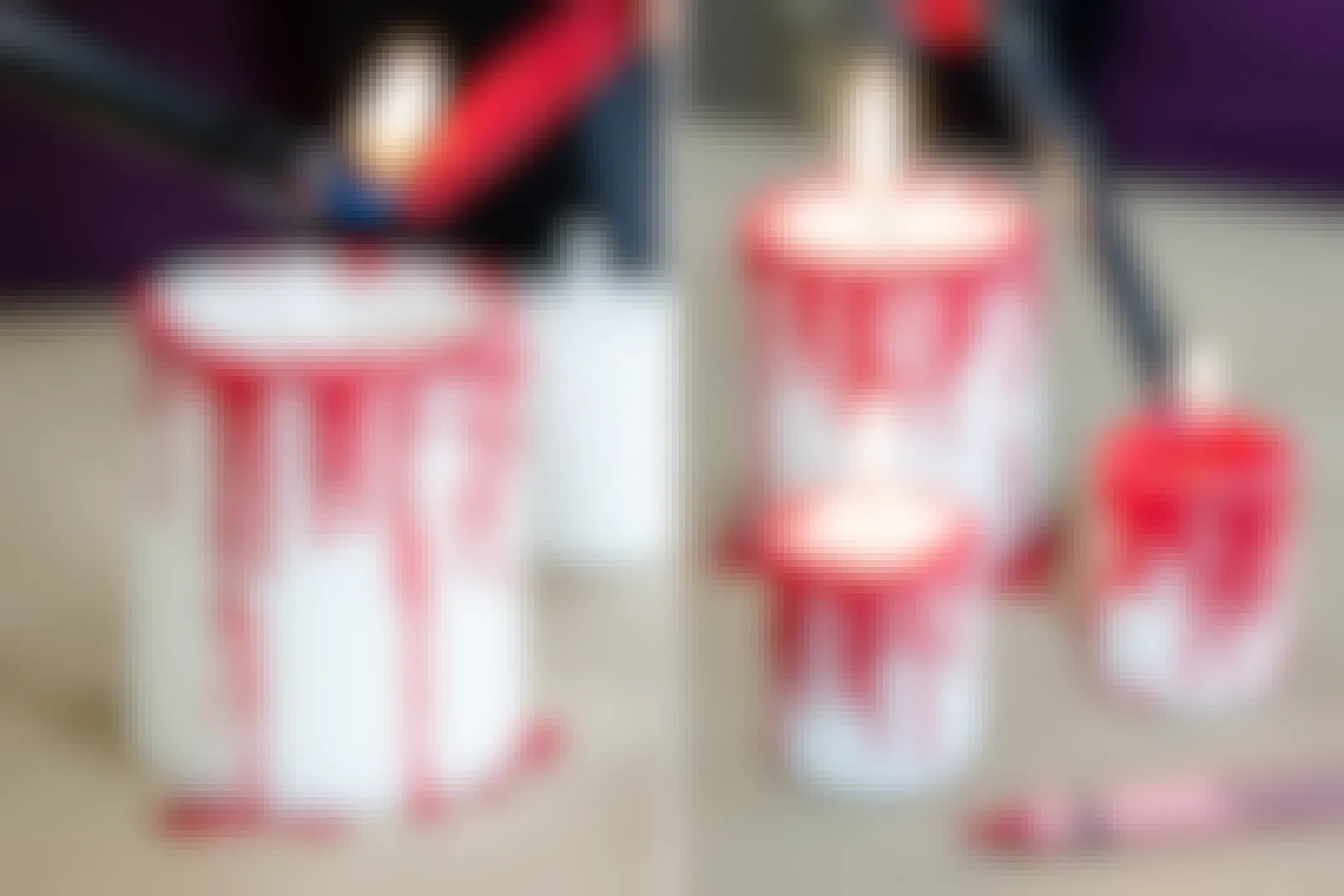 Two photos side-by-side; A person using a lighter to melt a red crayon all over the outside of a red white candle making drips down the side that look like blood. A person using a lighter to light one of the candles with crayon melted down the sides. Two other candles are already lit.