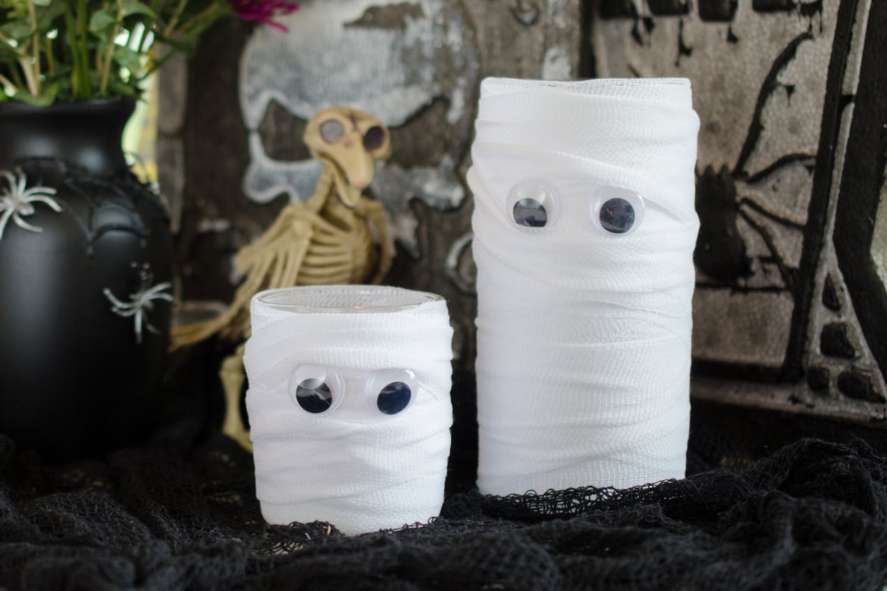 Vases wrapped in guys, with googly eyes glued to the front of them, making them look like mummies.