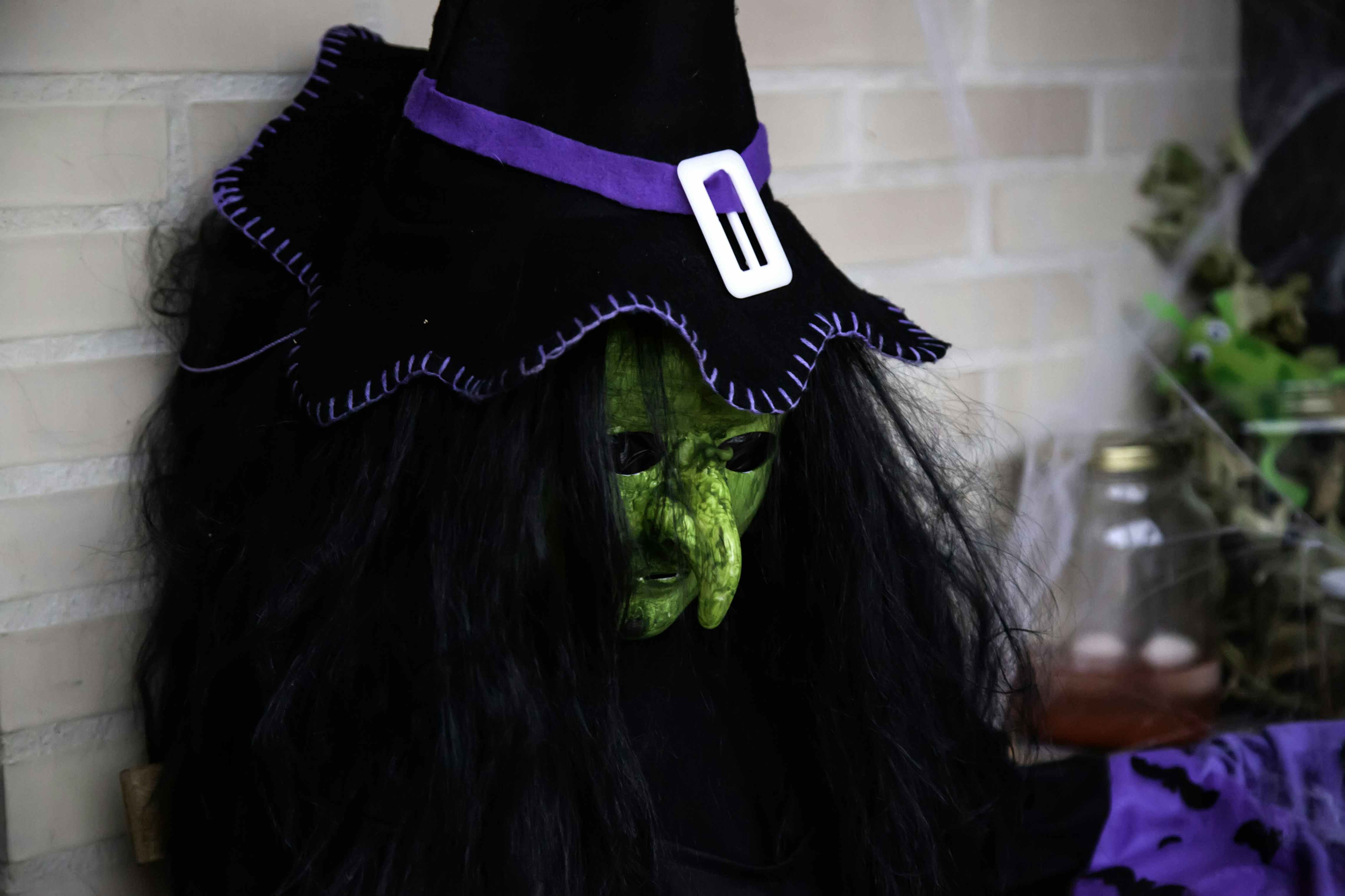 A witch costume sitting on a porch, waiting to be put up for decor.