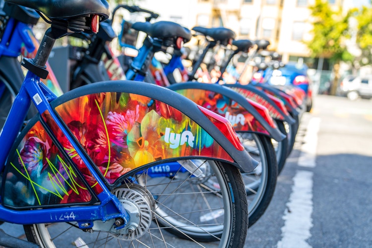 a row of Lyft ebikes in a city