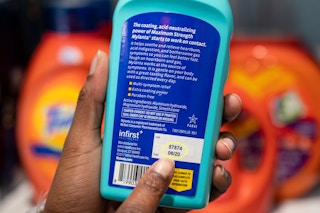 A person pointing out the expiration date on a bottle of Mylanta