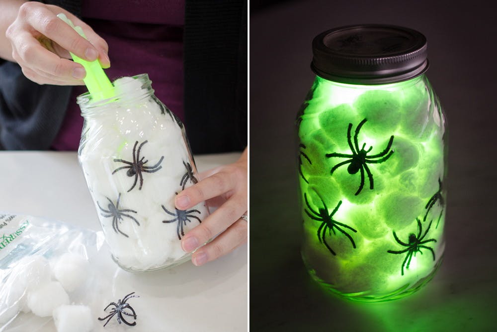 Someone putting glow sticks into mason jar filled with cotton balls and fake spiders, and a finished jar lit up green with spiders.