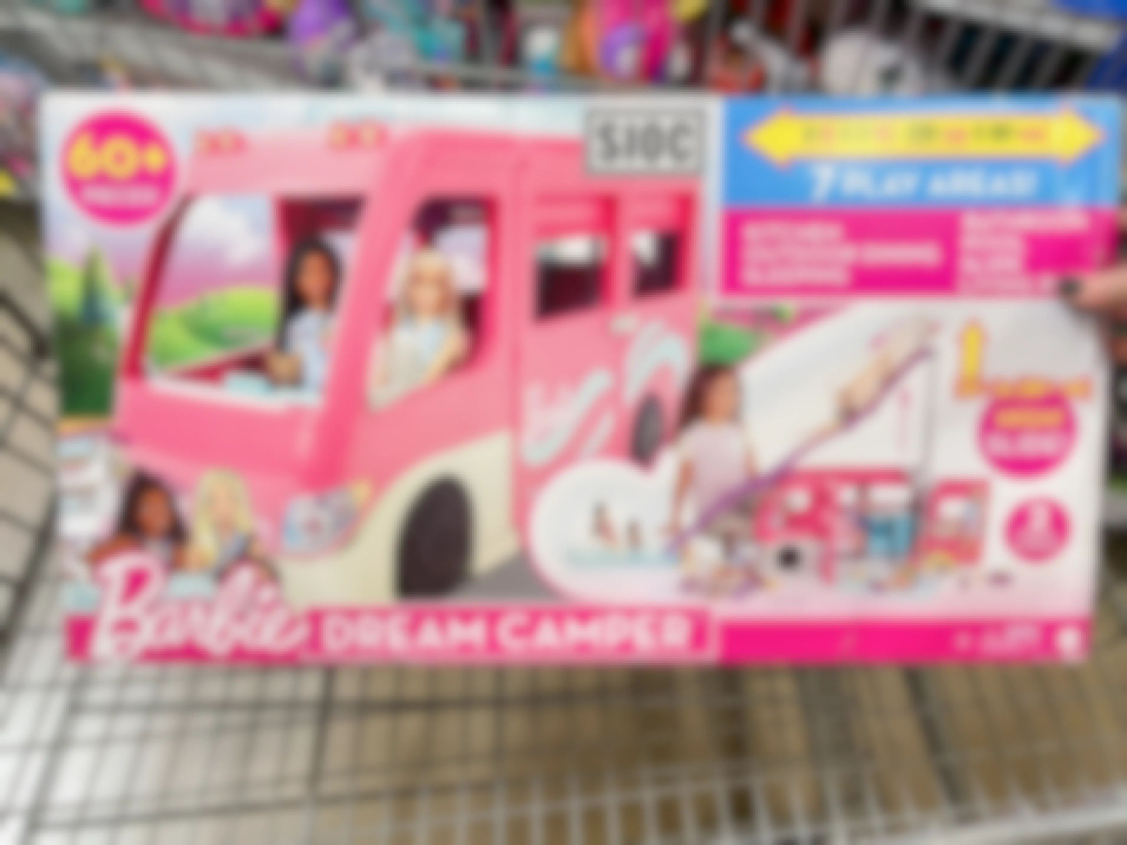 A Barbie DreamCamper set in a shopping cart.