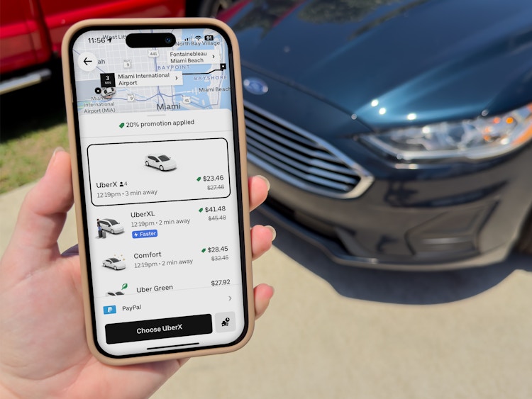 someone holding up a phone showing the Uber app with ride options