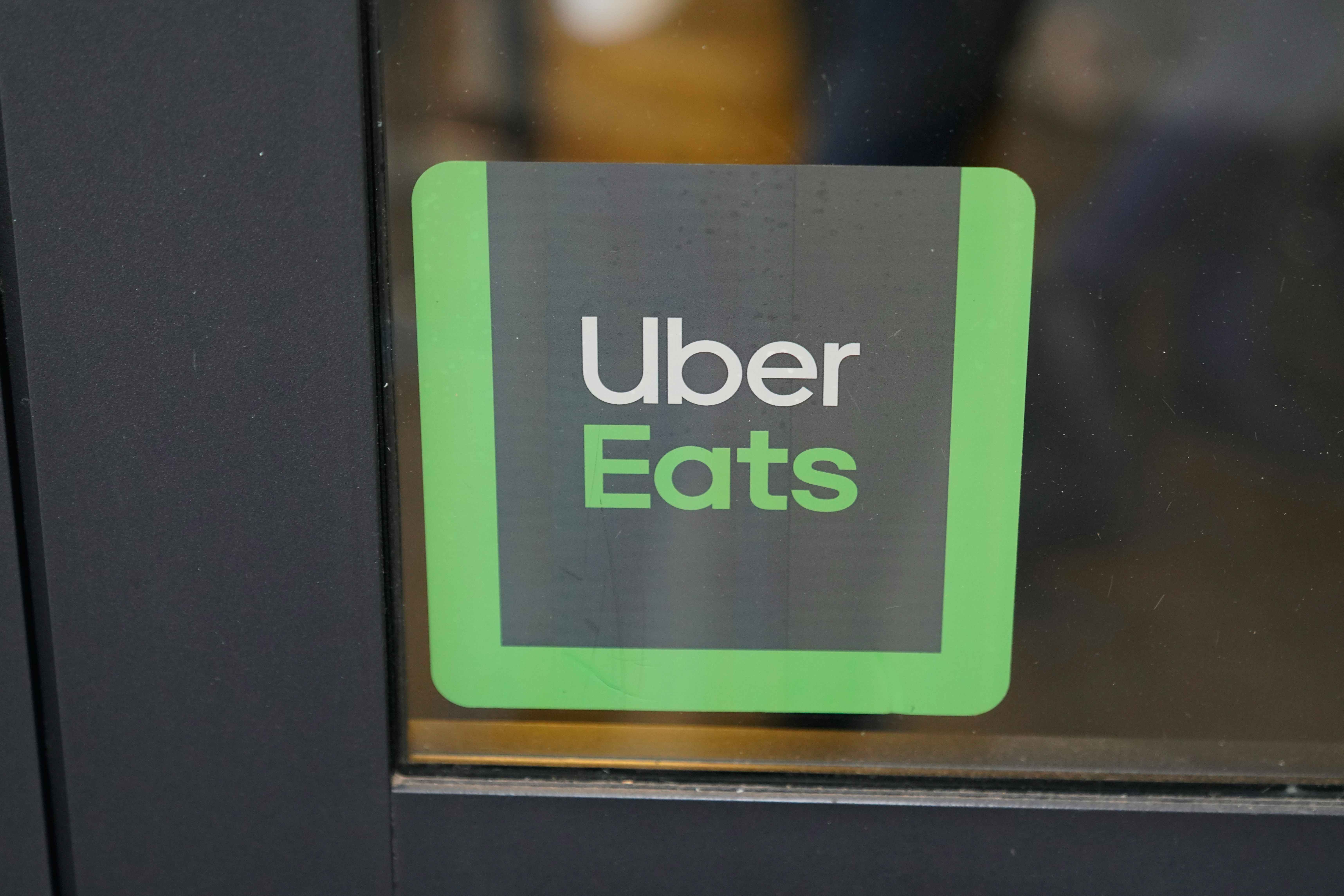 An Uber Eats sticker on a glass restaurant window.