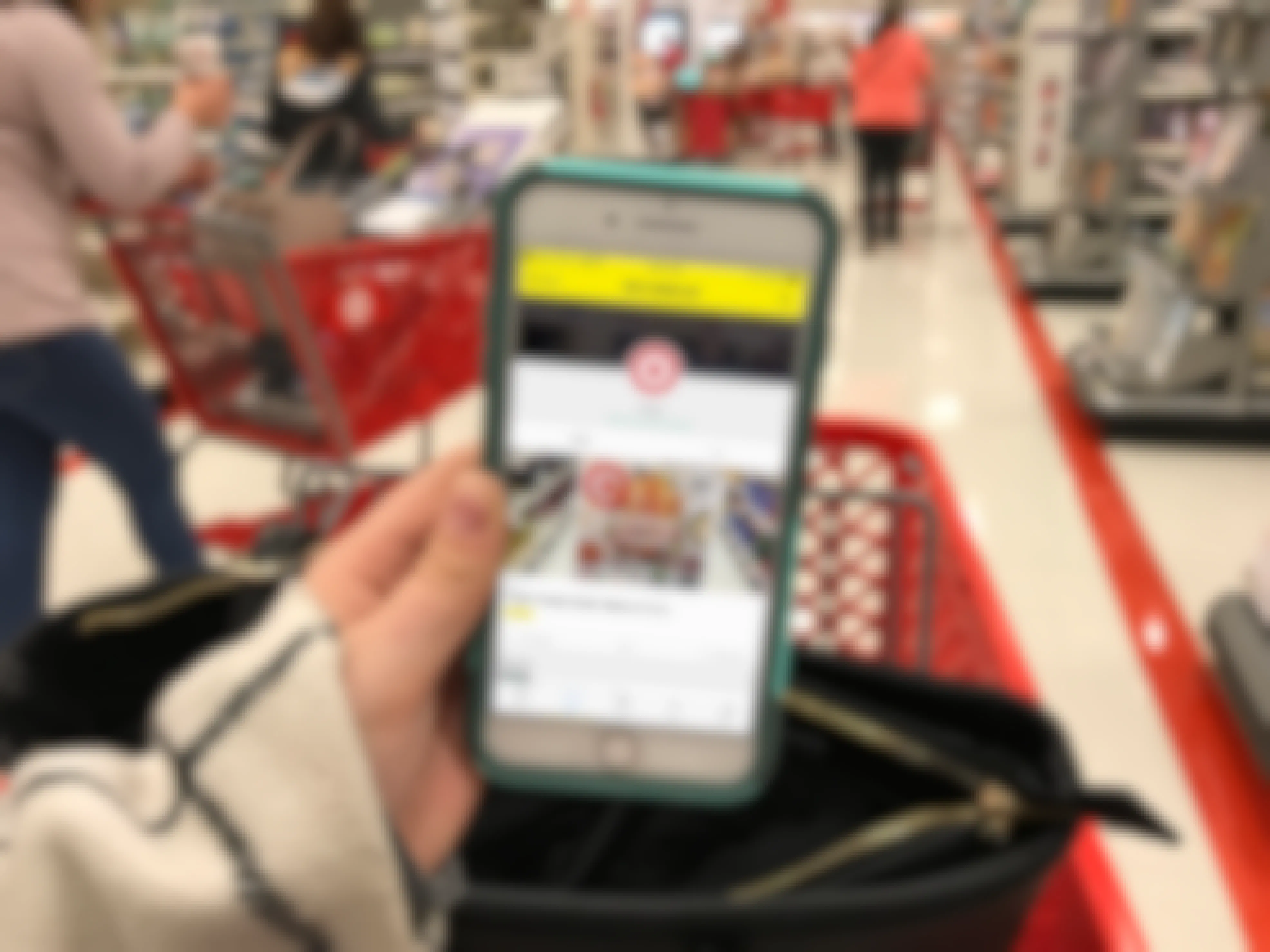 A person looking at their phone displaying the Target page of the KrazyCouponLady app.
