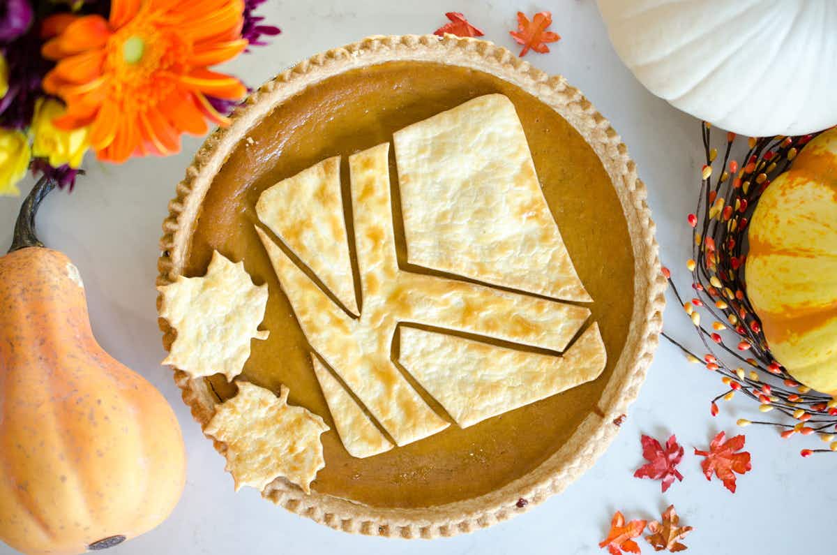 pumpkin pie with KCL icon baked into it surrounded by fall decor