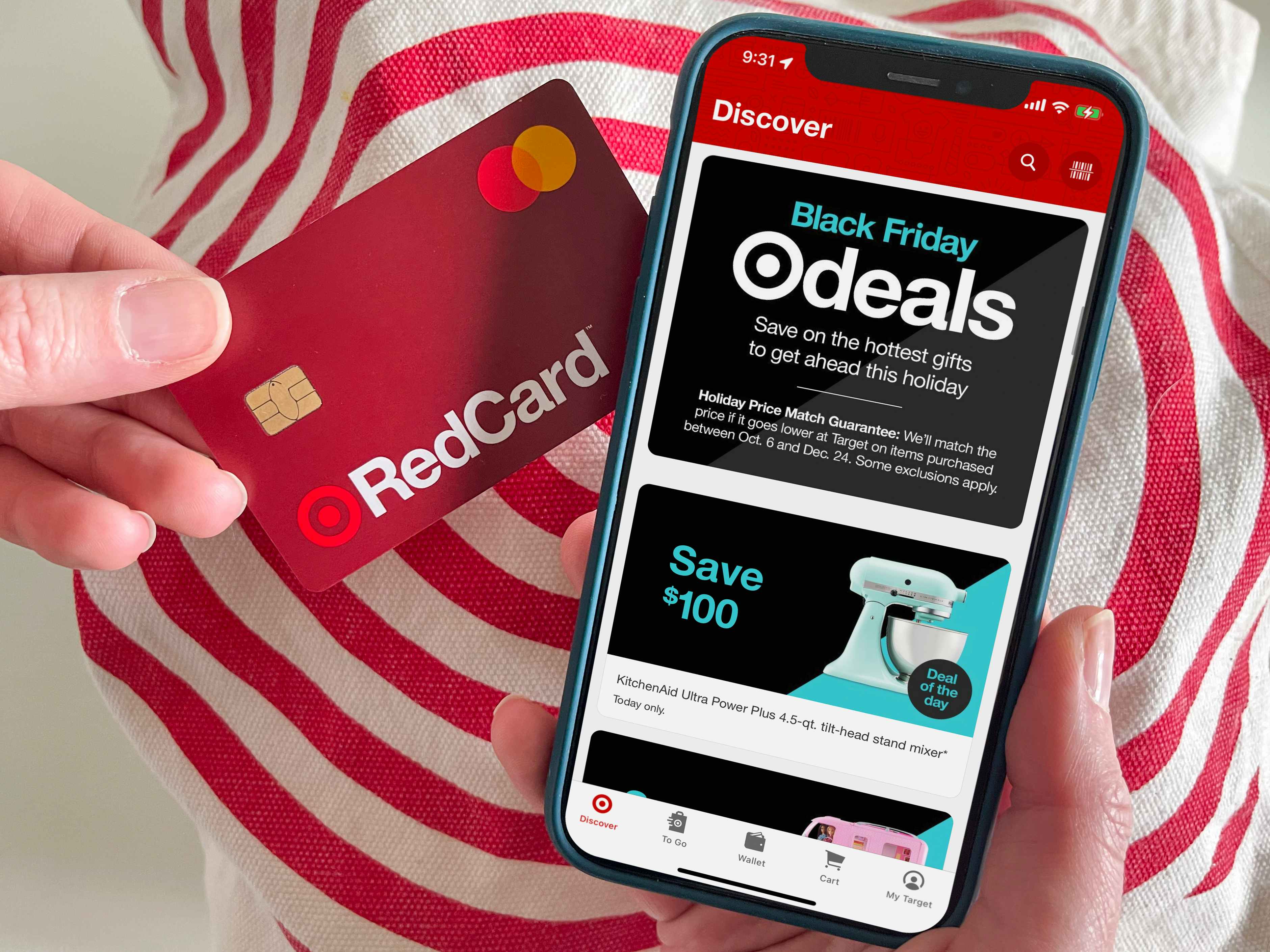A person holding a black friday credit card next to the Target app with Black Friday deals on the screen.