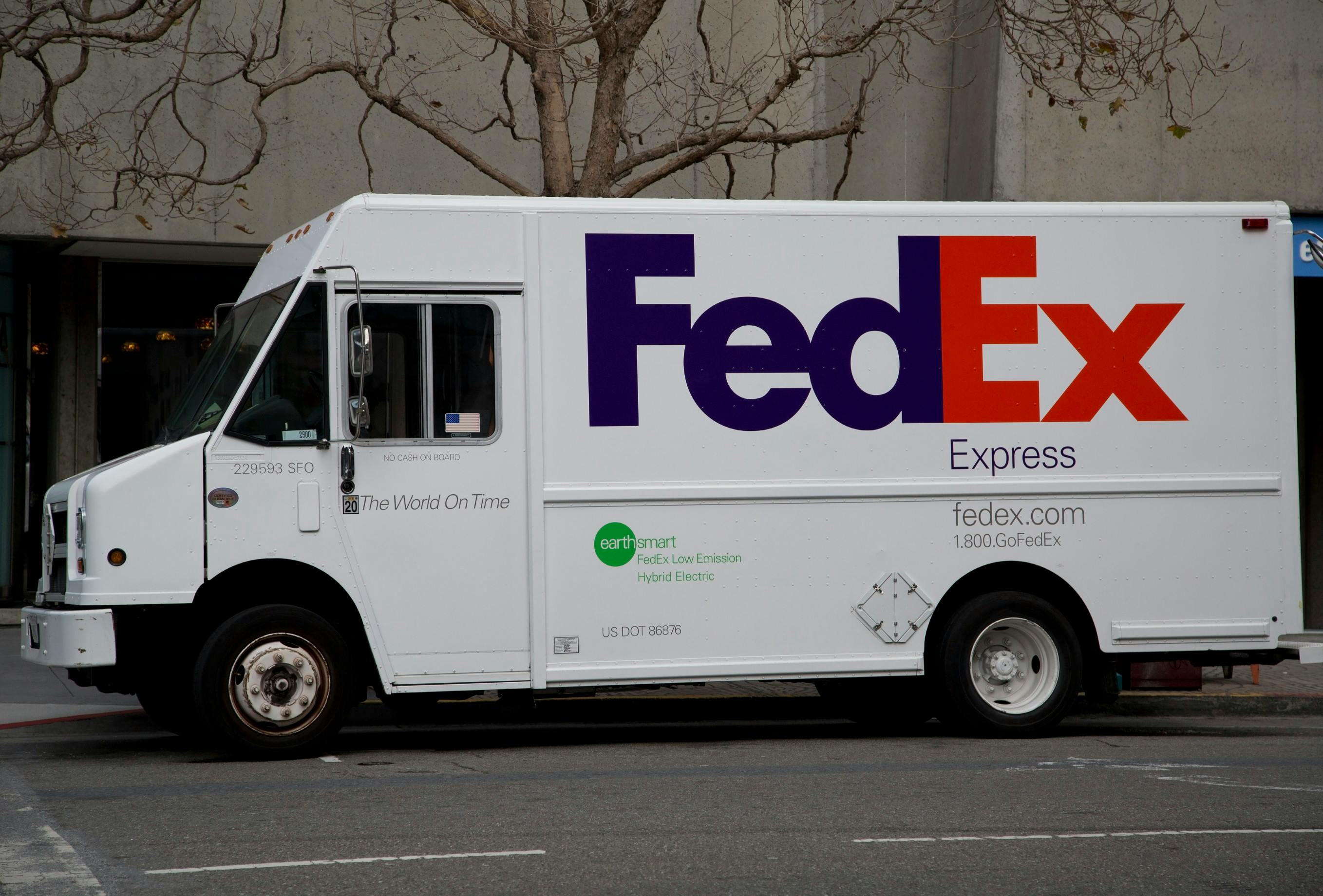 Fedex truck parked by a sidewalk