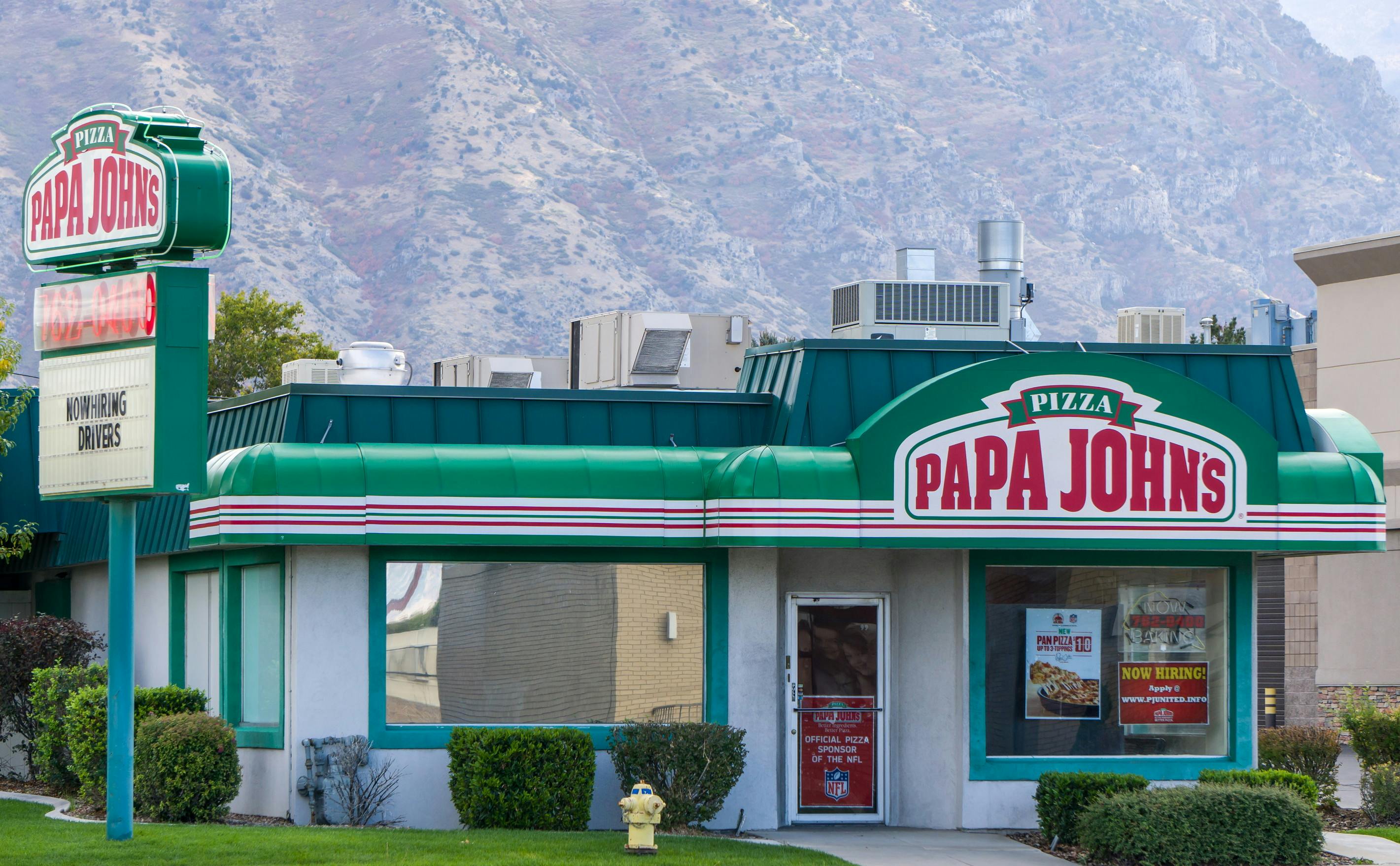 A Papa John's restaurant with mountains in the background
