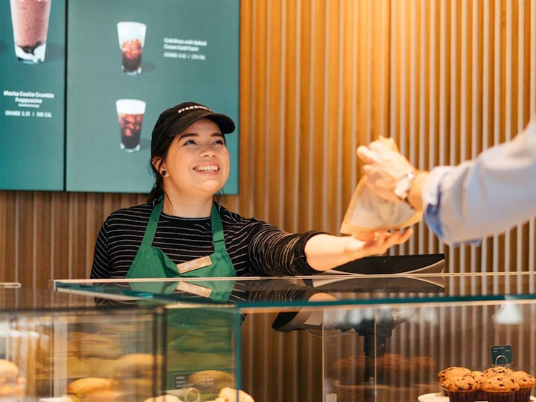 starbuck employee handing customer bag