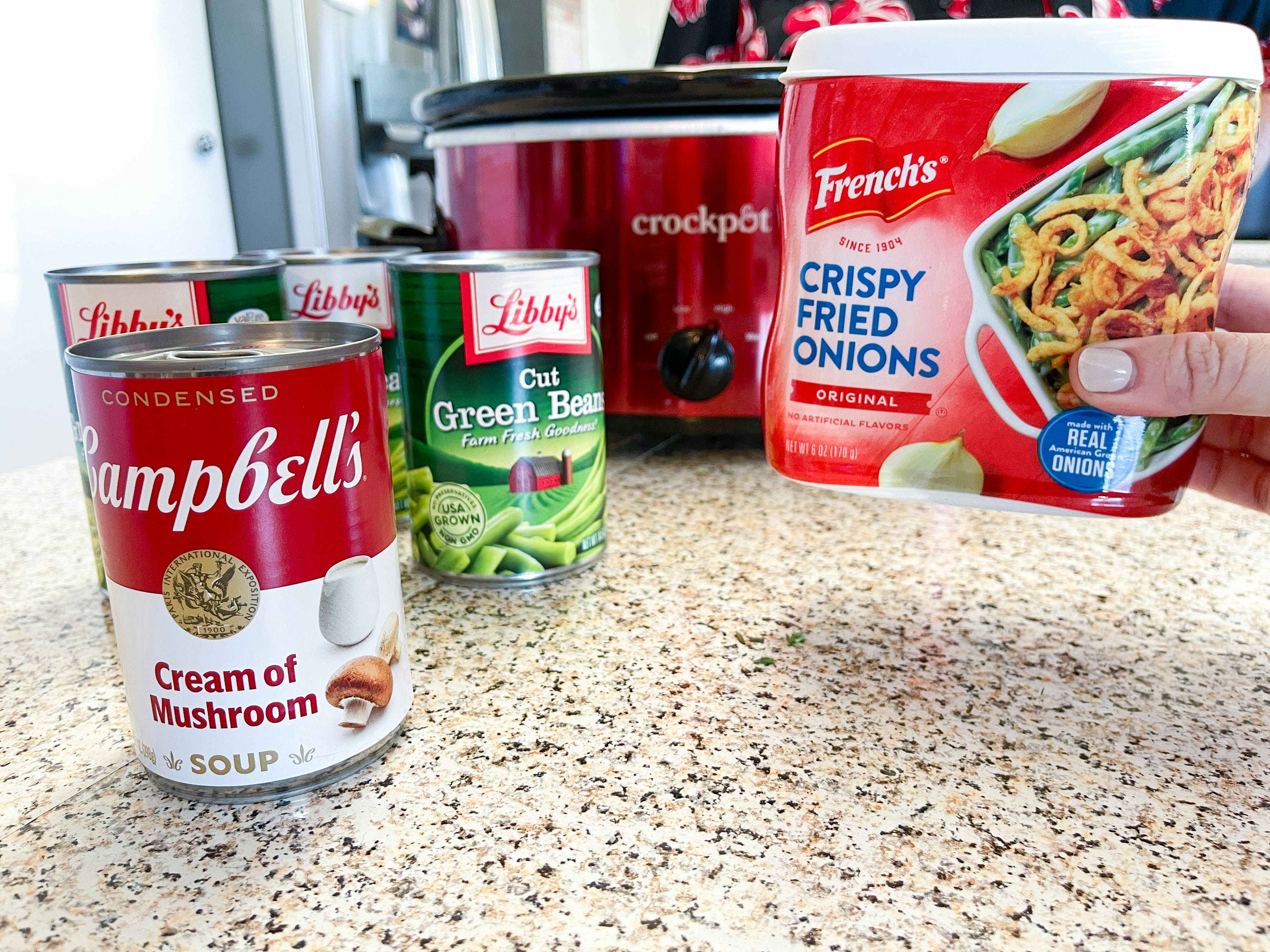 Ingredients for green bean casserole in front of a crock pot.