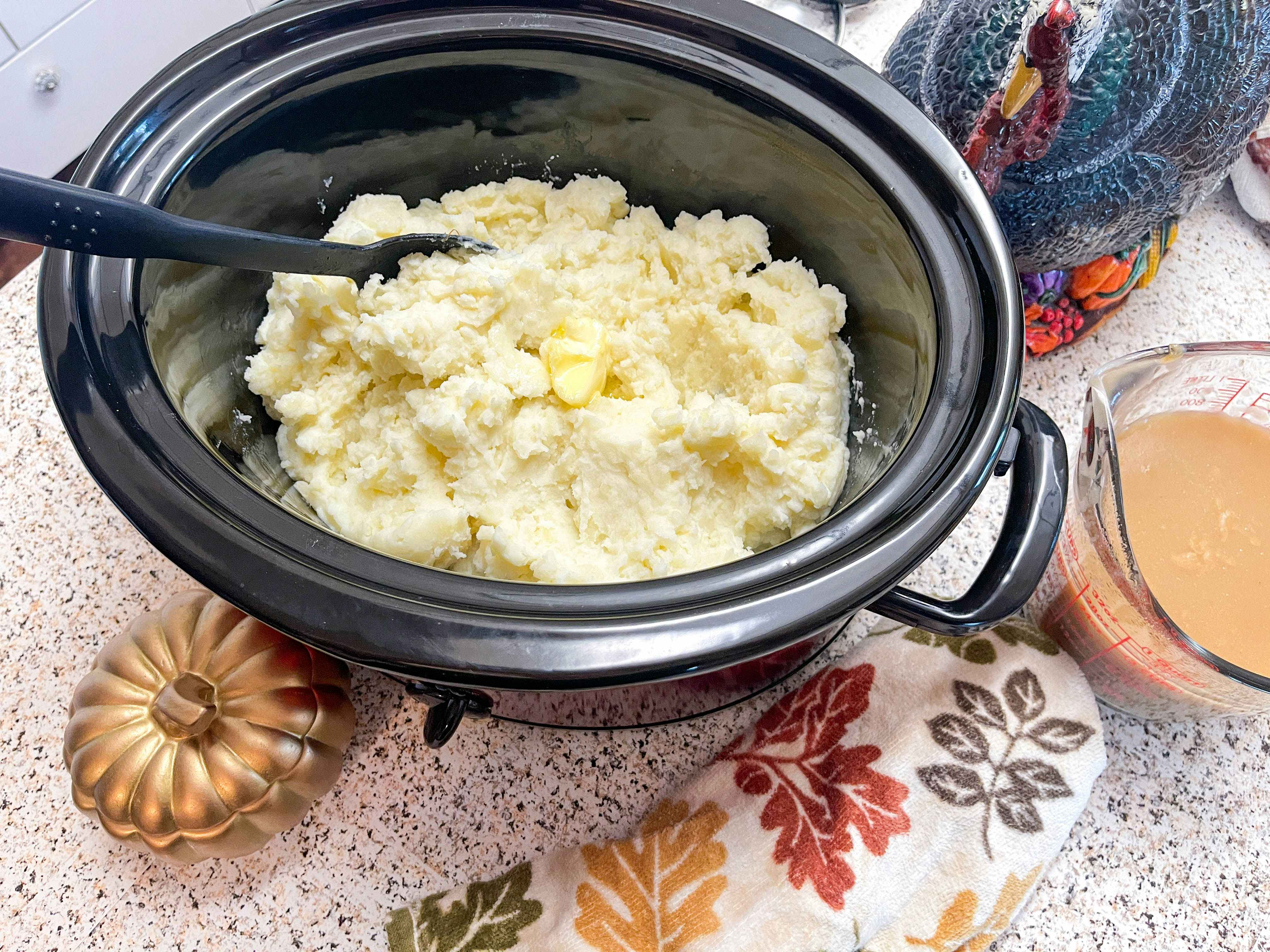 A slow cooker filled with mashed potatoes.