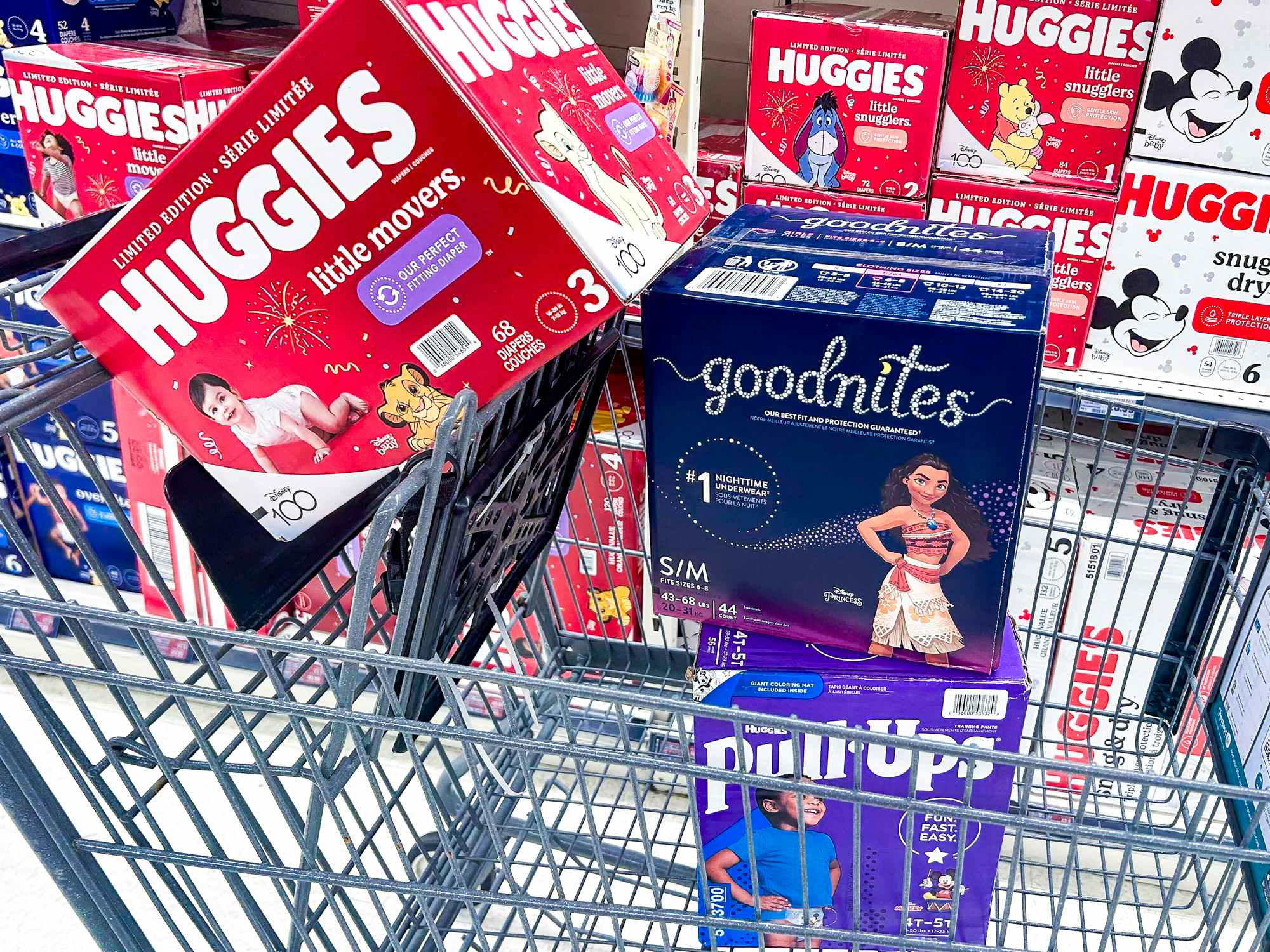 a stack of huggies, goodnites, and pull ups in a cart