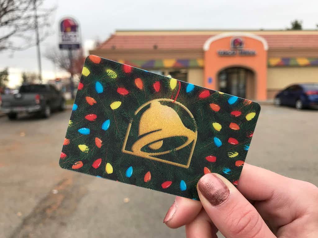 Person holding a holiday themed taco bell gift card
