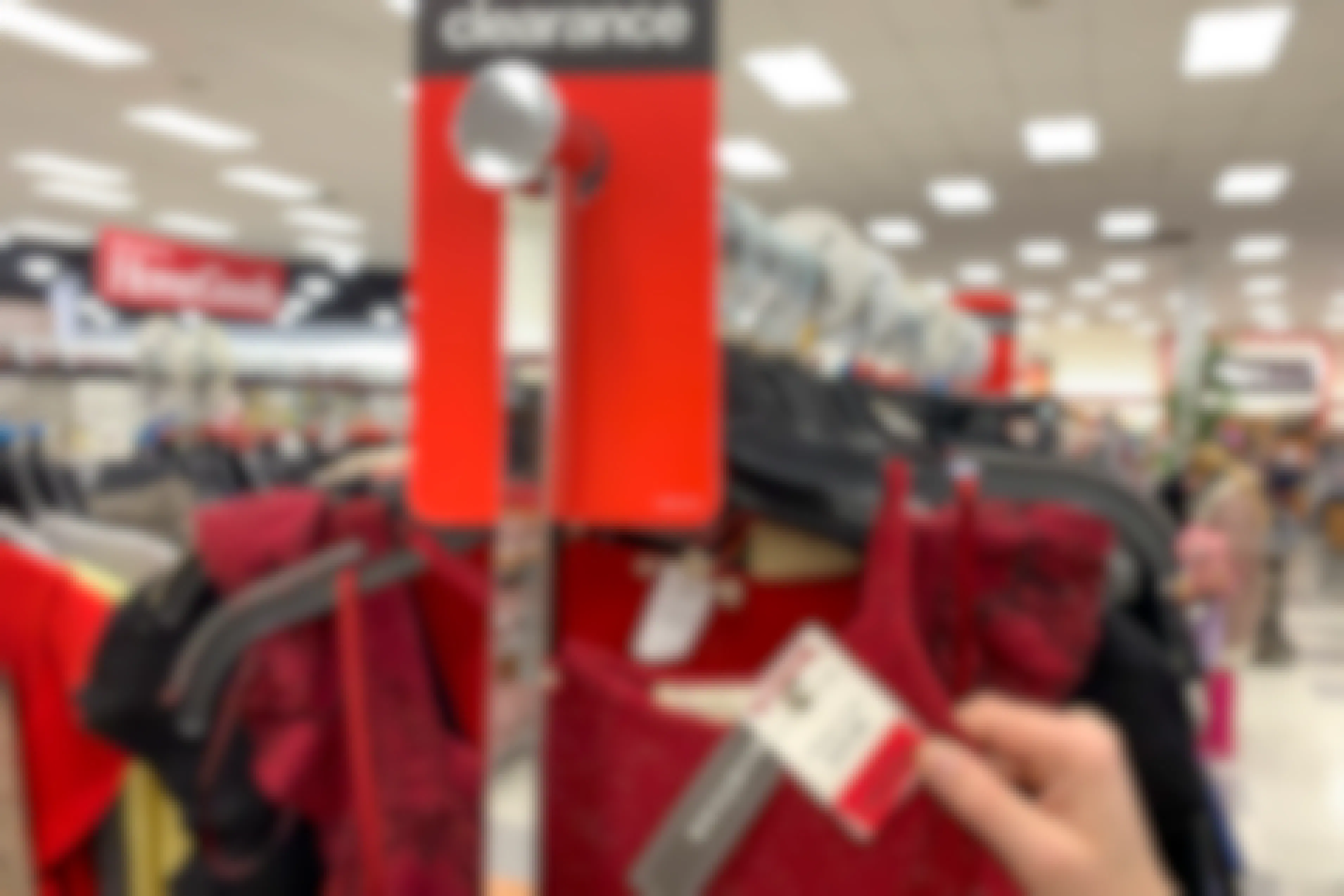 A red clearance sales tag attached to a red dress on a clearance rack.