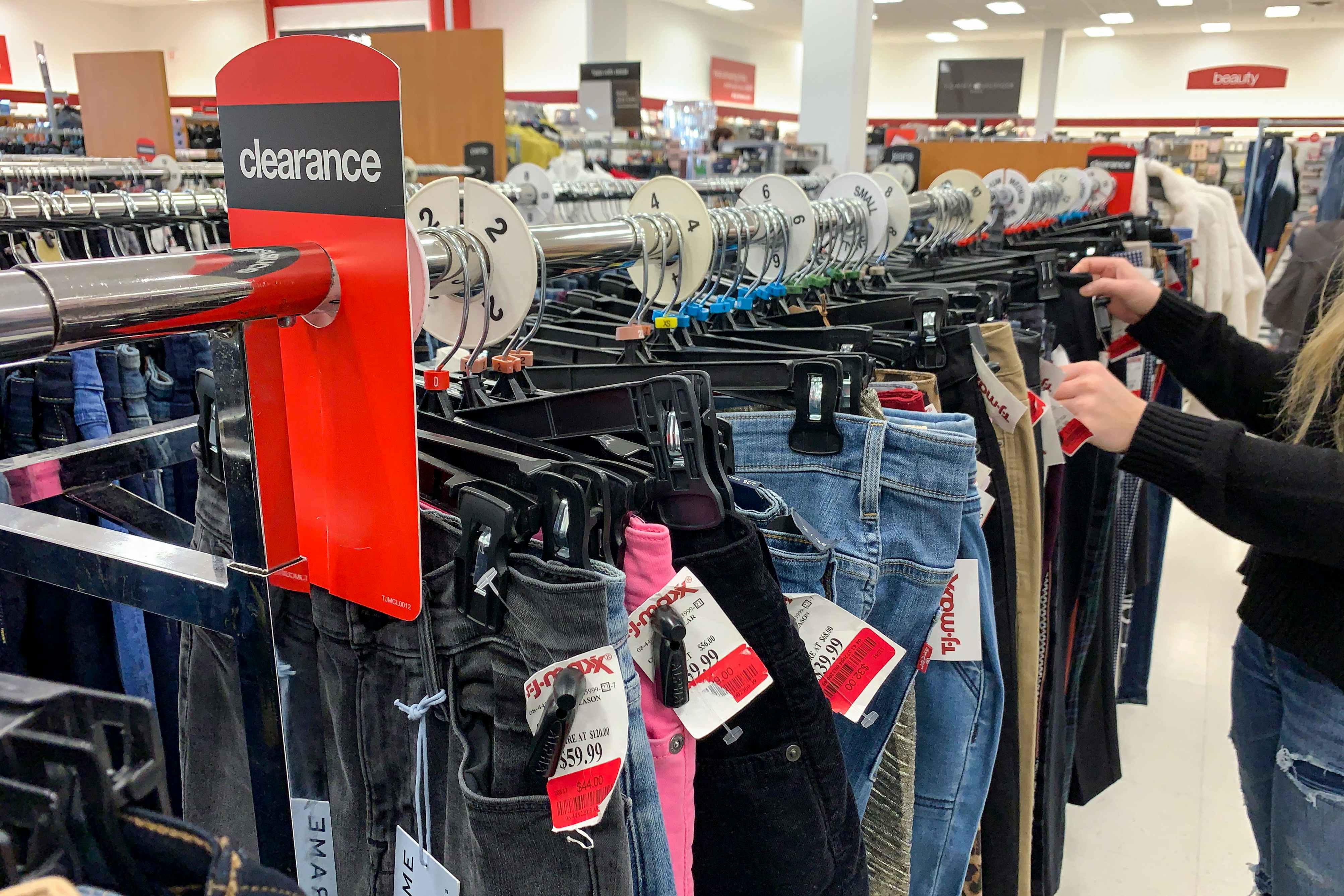 A woman going through clothing on a clearance rack.