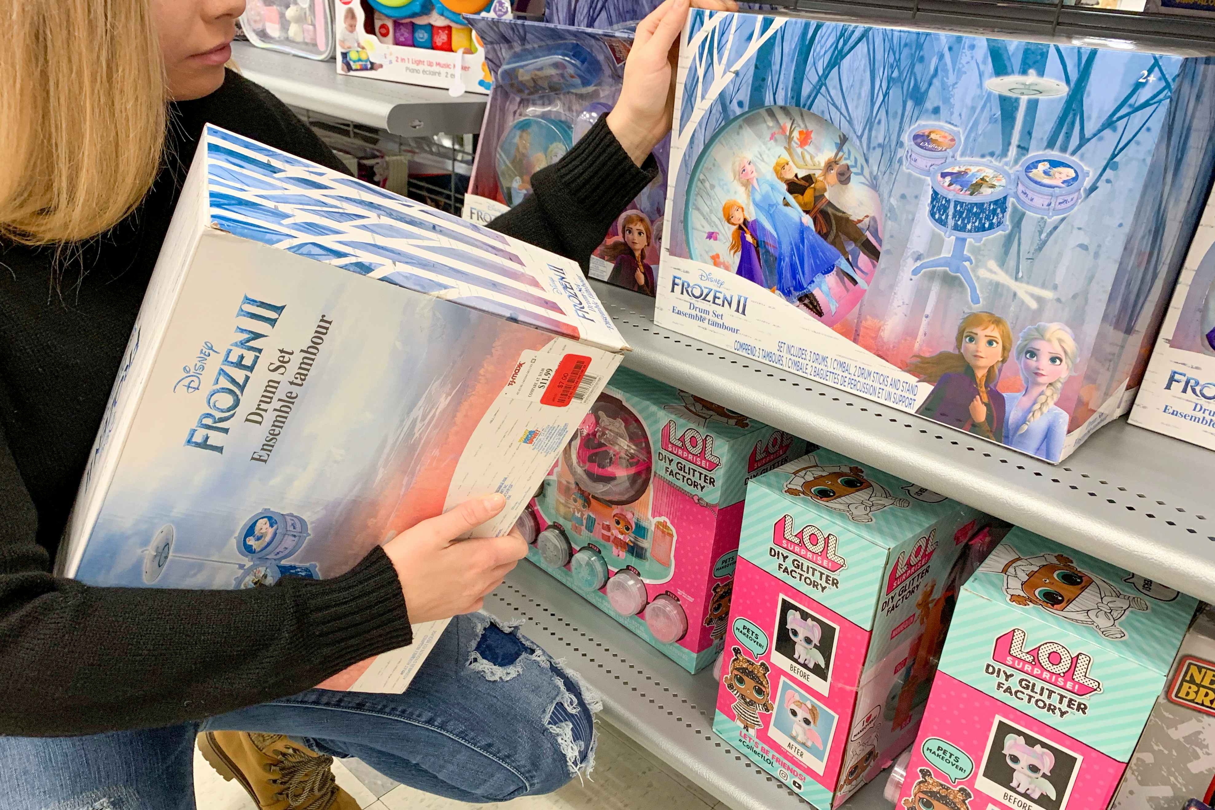A woman looking at a Disney's Frozen 2 toy drum set.