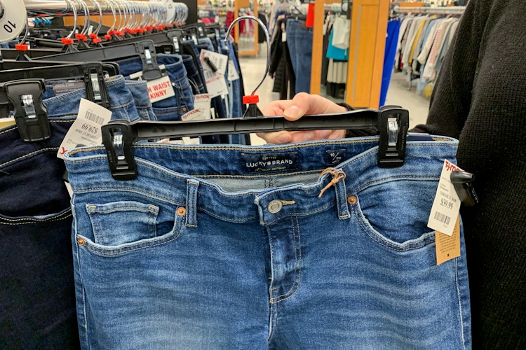 A woman holding Lucky Brand jeans.