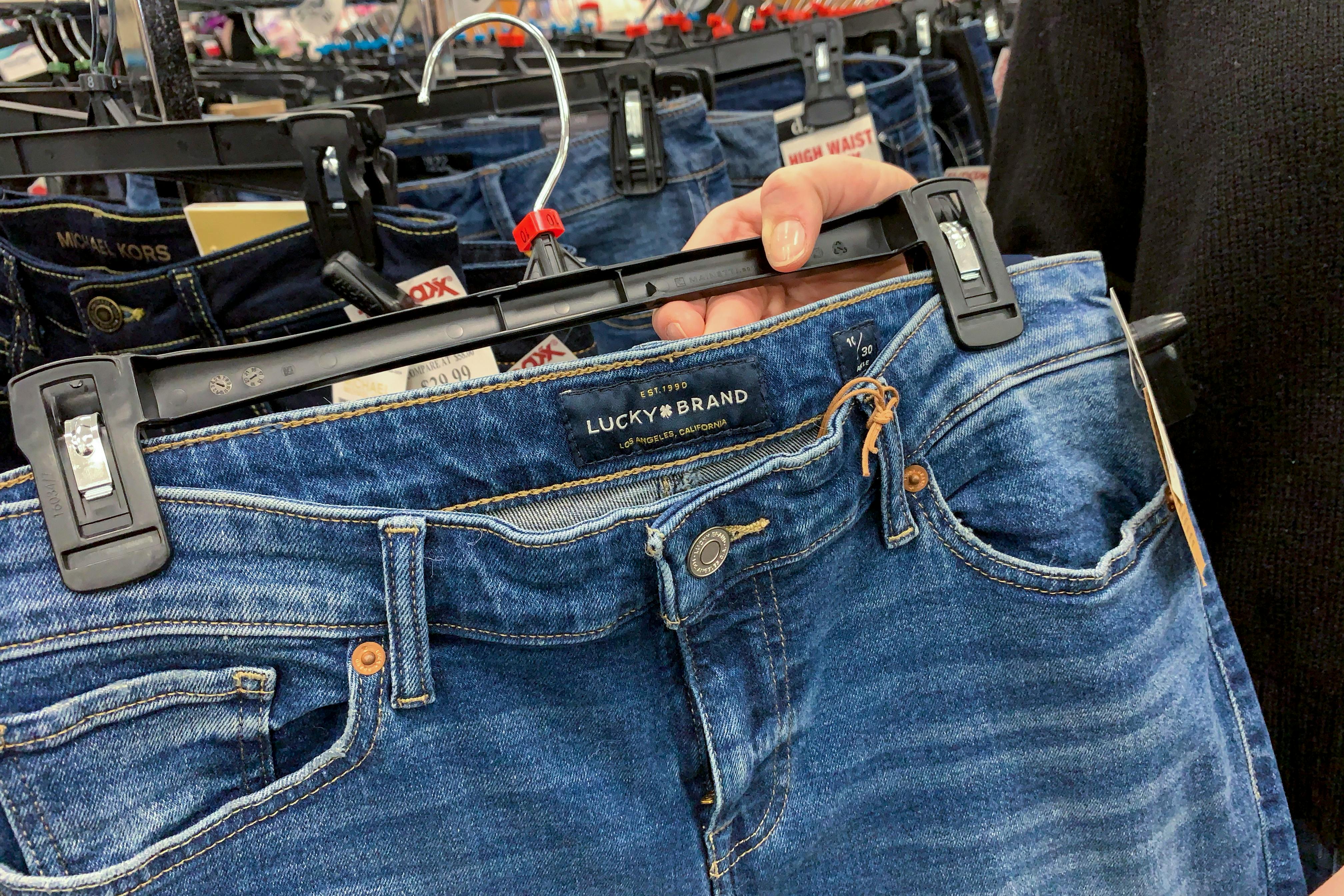 A woman holding Lucky Brand jeans.