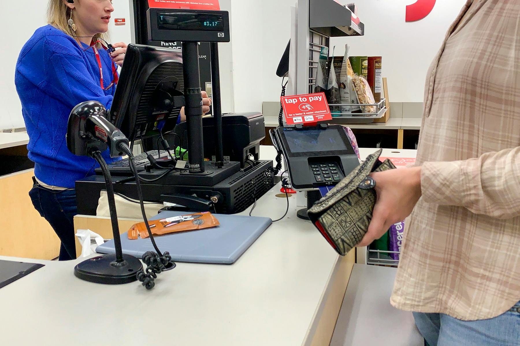 A women purchasing items at the register.