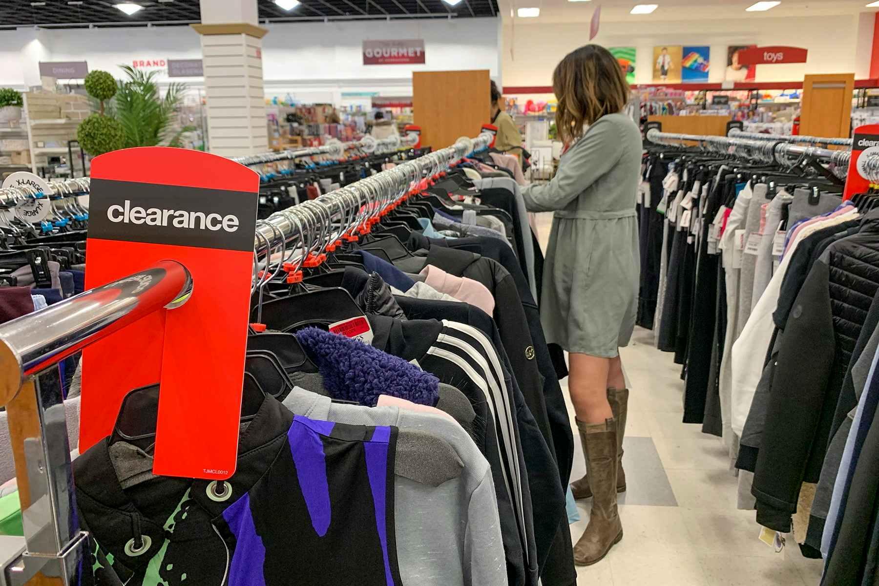 A woman looking through the clearance clothing rack.
