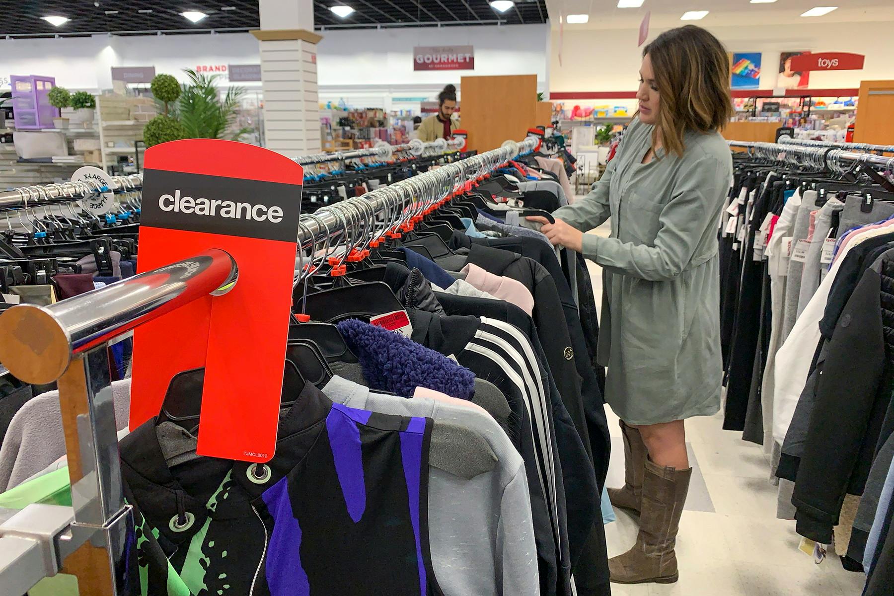A woman looking through the clearance clothing rack.