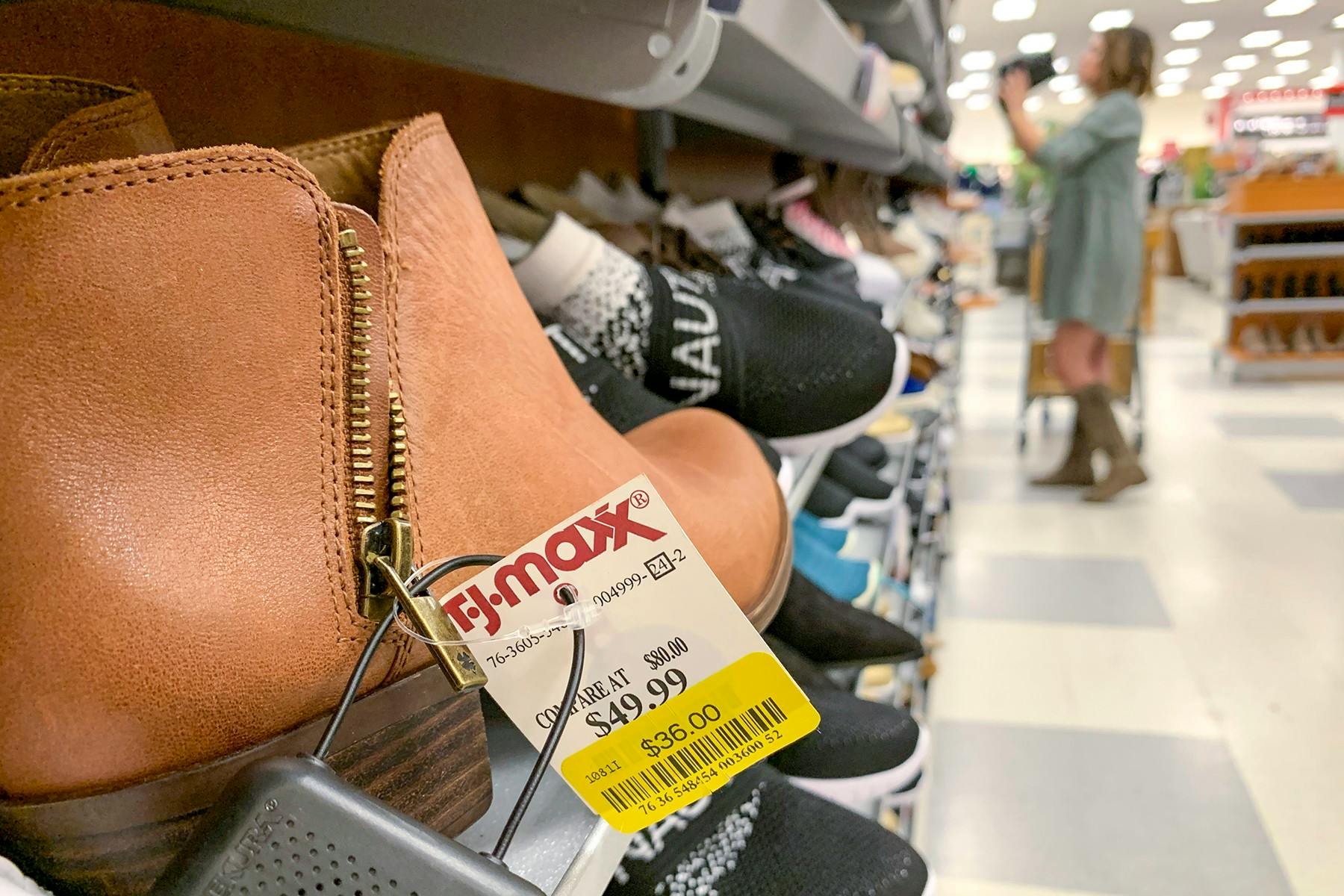 A pair of brown ankle boots with a yellow clearance tag on them.