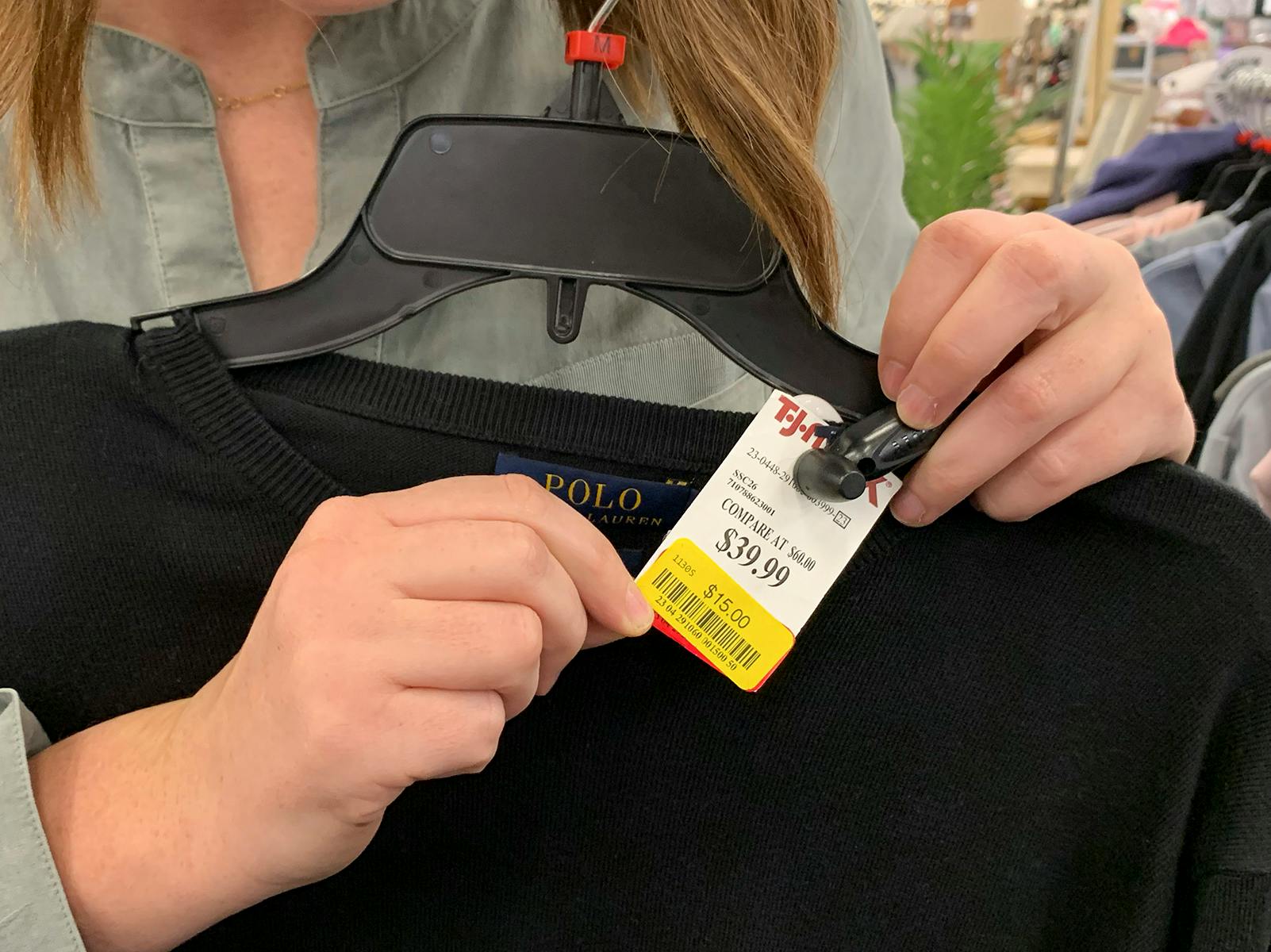 A price tag with a yellow clearance sticker on a mens sweater.