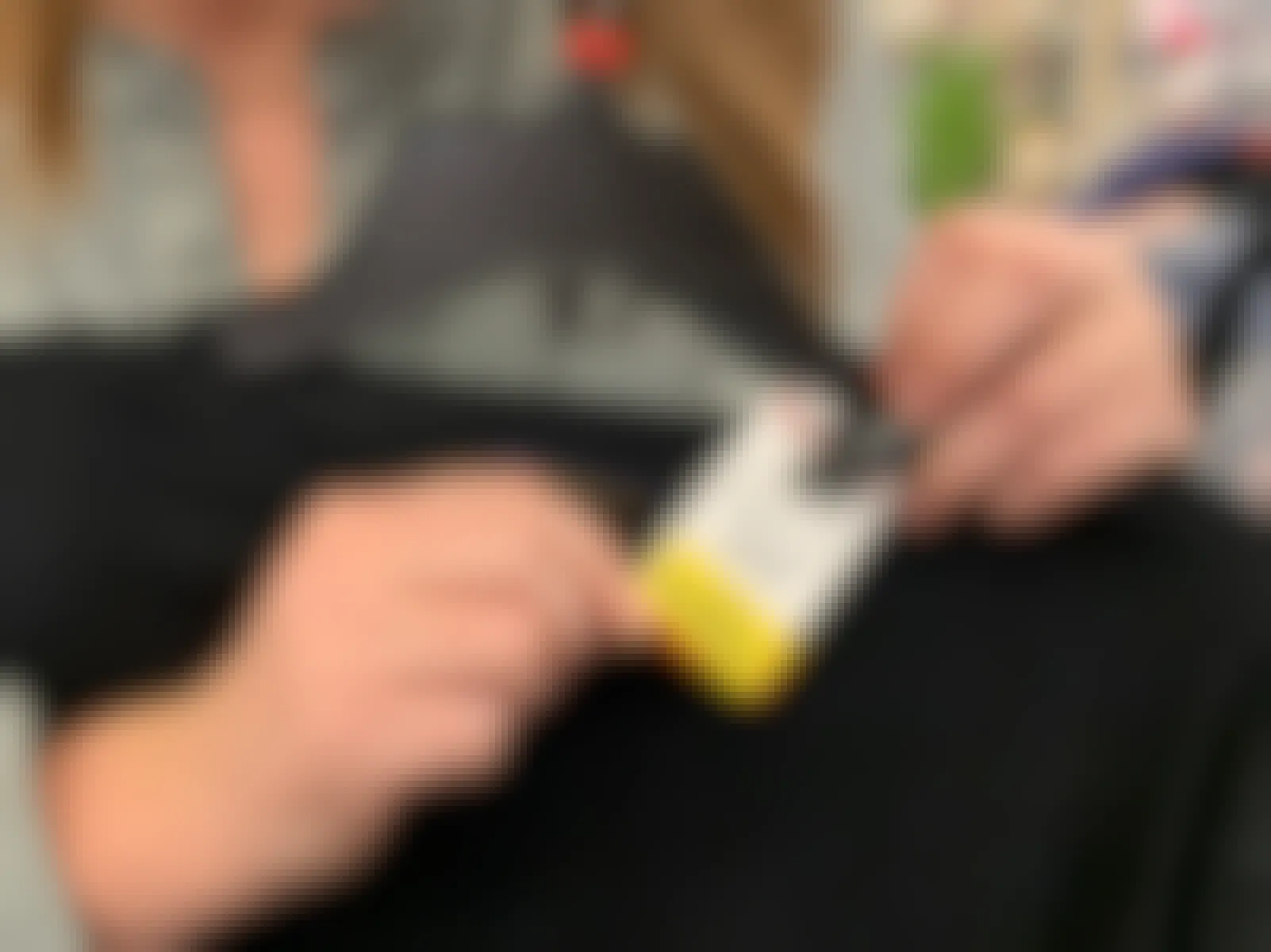 A price tag with a yellow clearance sticker on a mens sweater.