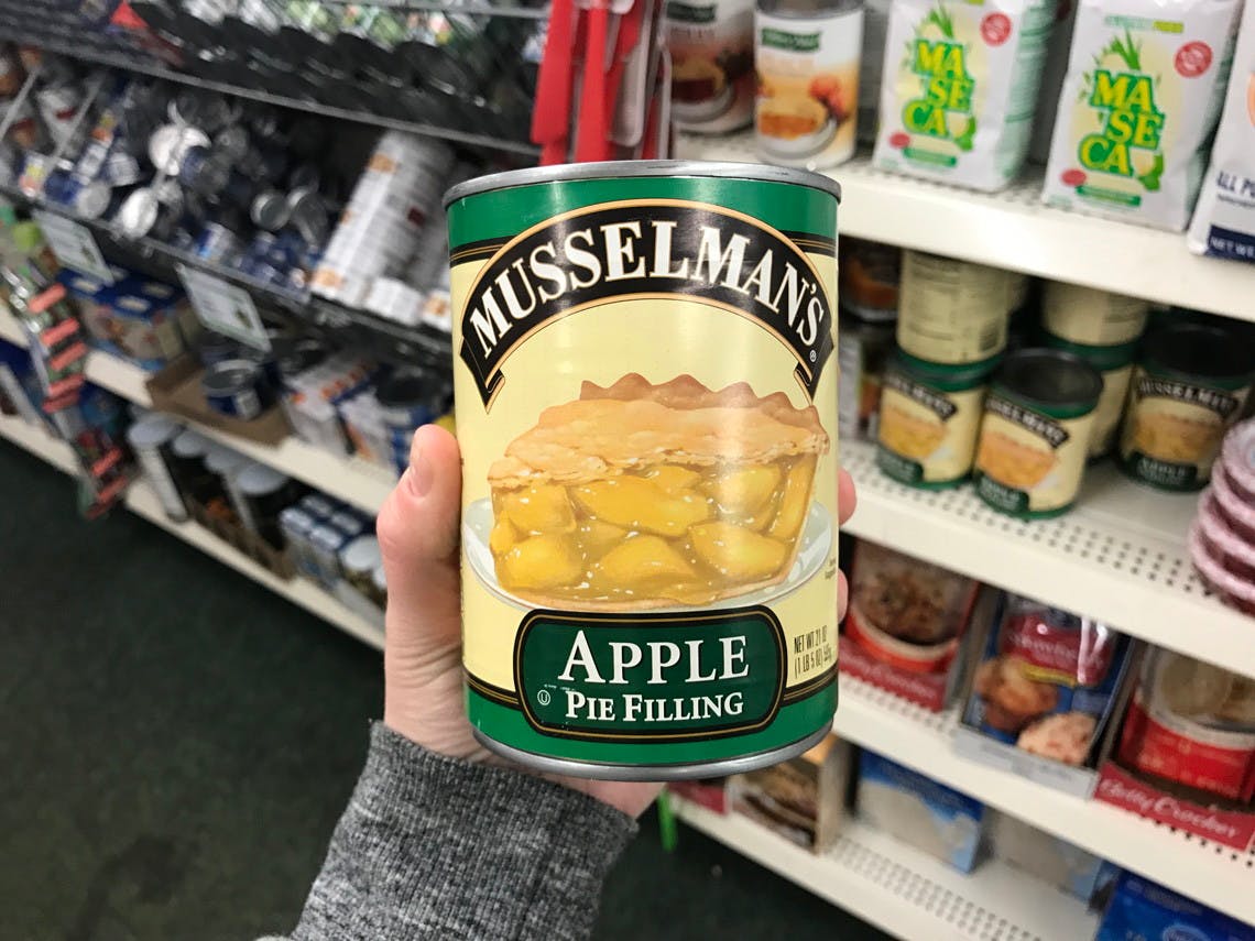 hand holding Musselmans apples at Dollar Tree