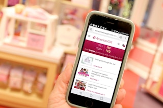 someone holding phone with americangirl website up