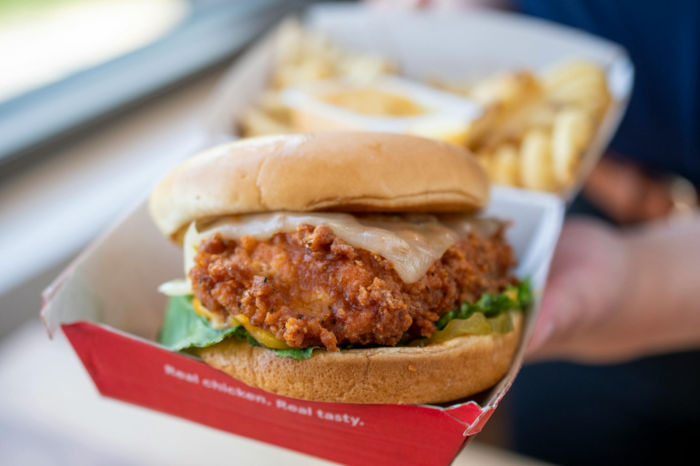 A close-up on a Chick-fil-A chicken sandwich and fries in a box.