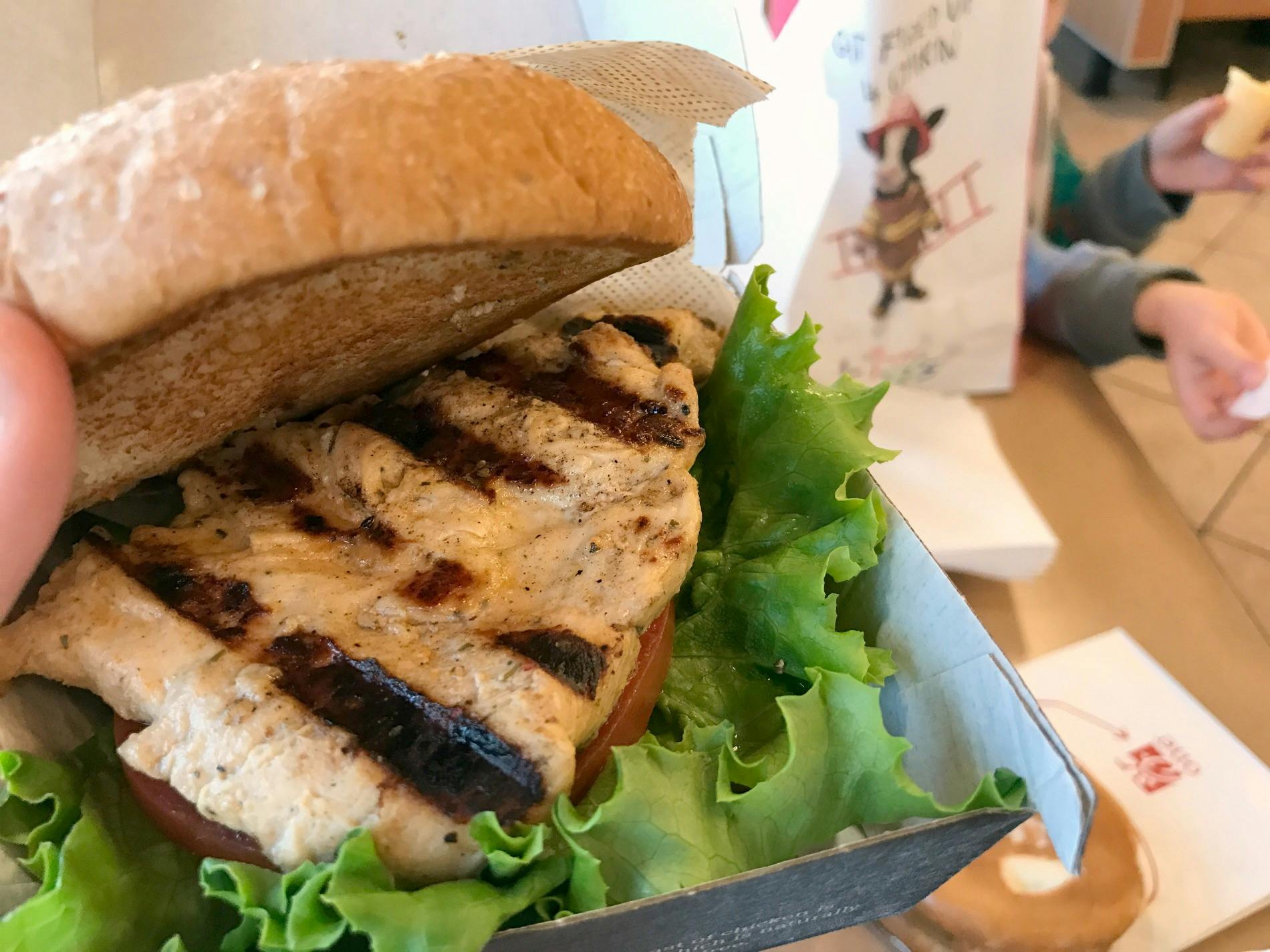 A close-up of a grilled chicken Chick-fil-A sandwich on a gluten free bun.