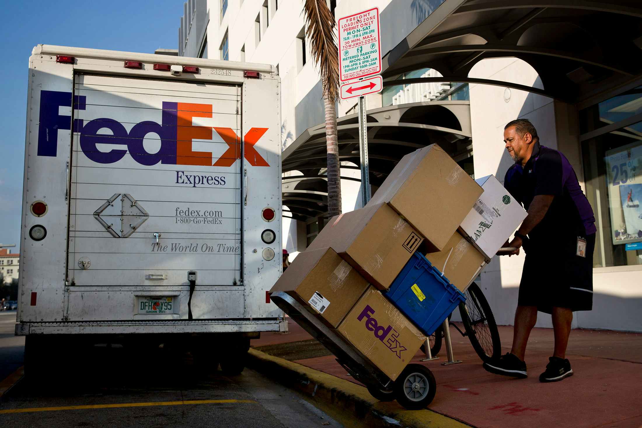 FedEx employee loads packages into a truck