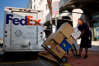 FedEx employee loads packages into a truck