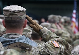American military soldiers saluting the American flag.