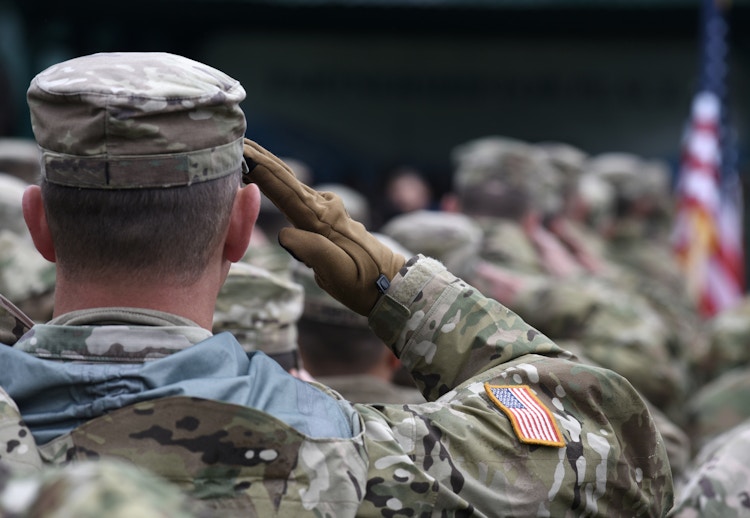 American military soldiers saluting the American flag.