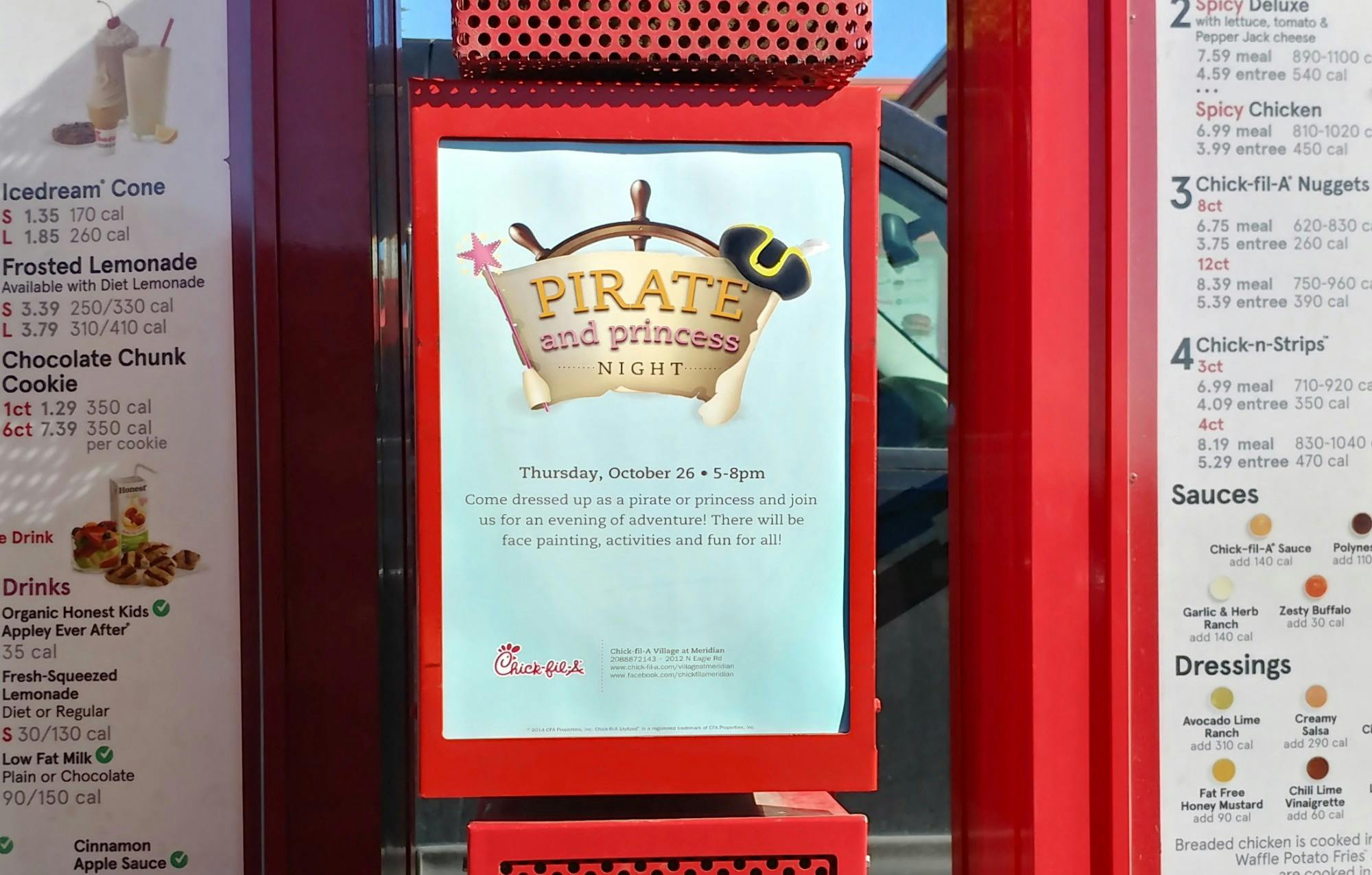A sign advertising Pirate and Princess Night at Chick-fil-A displayed by the drive-thru menu.