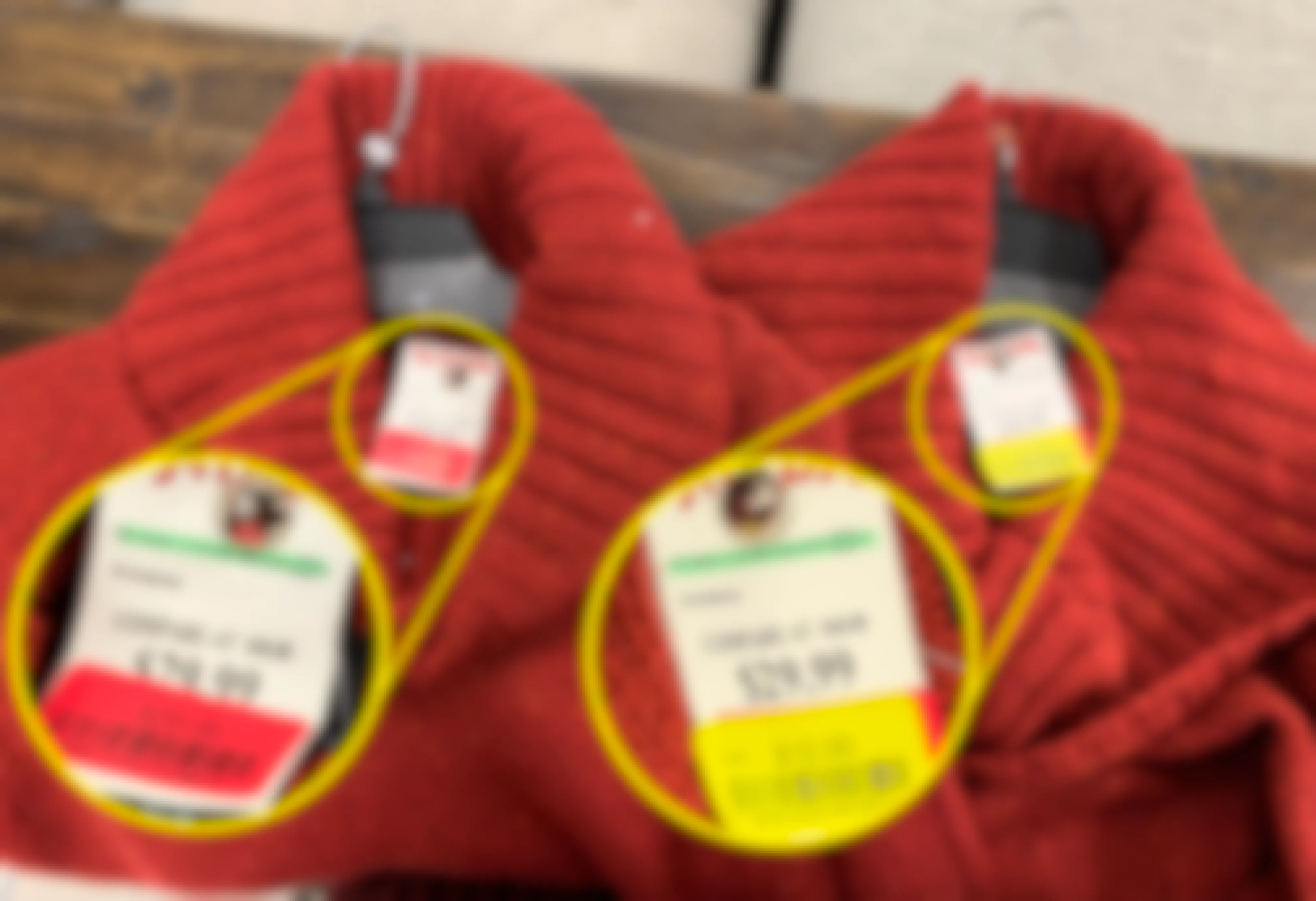 Two identical red sweaters with different prices on the tags, but same style numbers