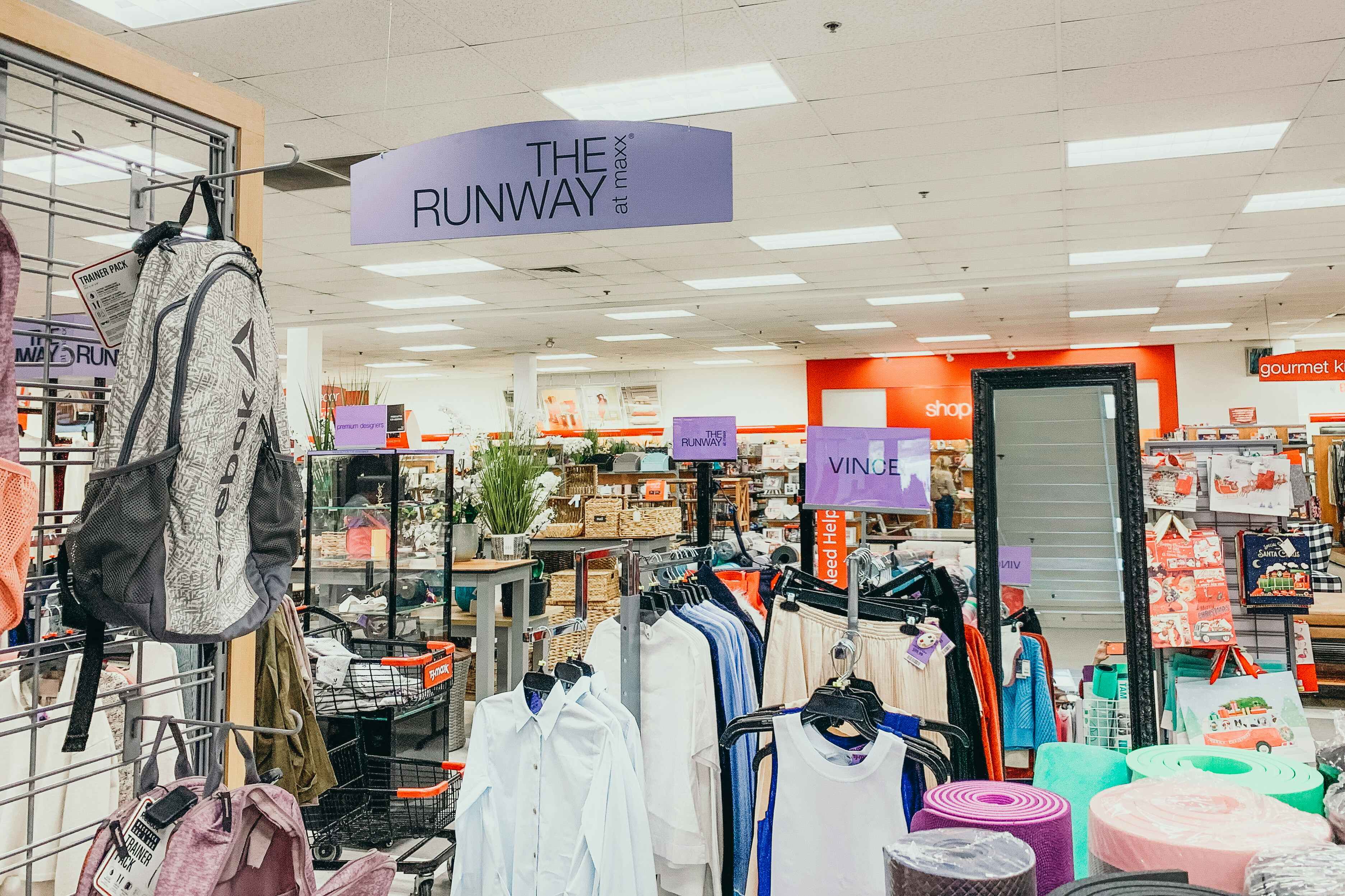 Interior of a TJ Maxx store Runway section showing signs for brands like Vince