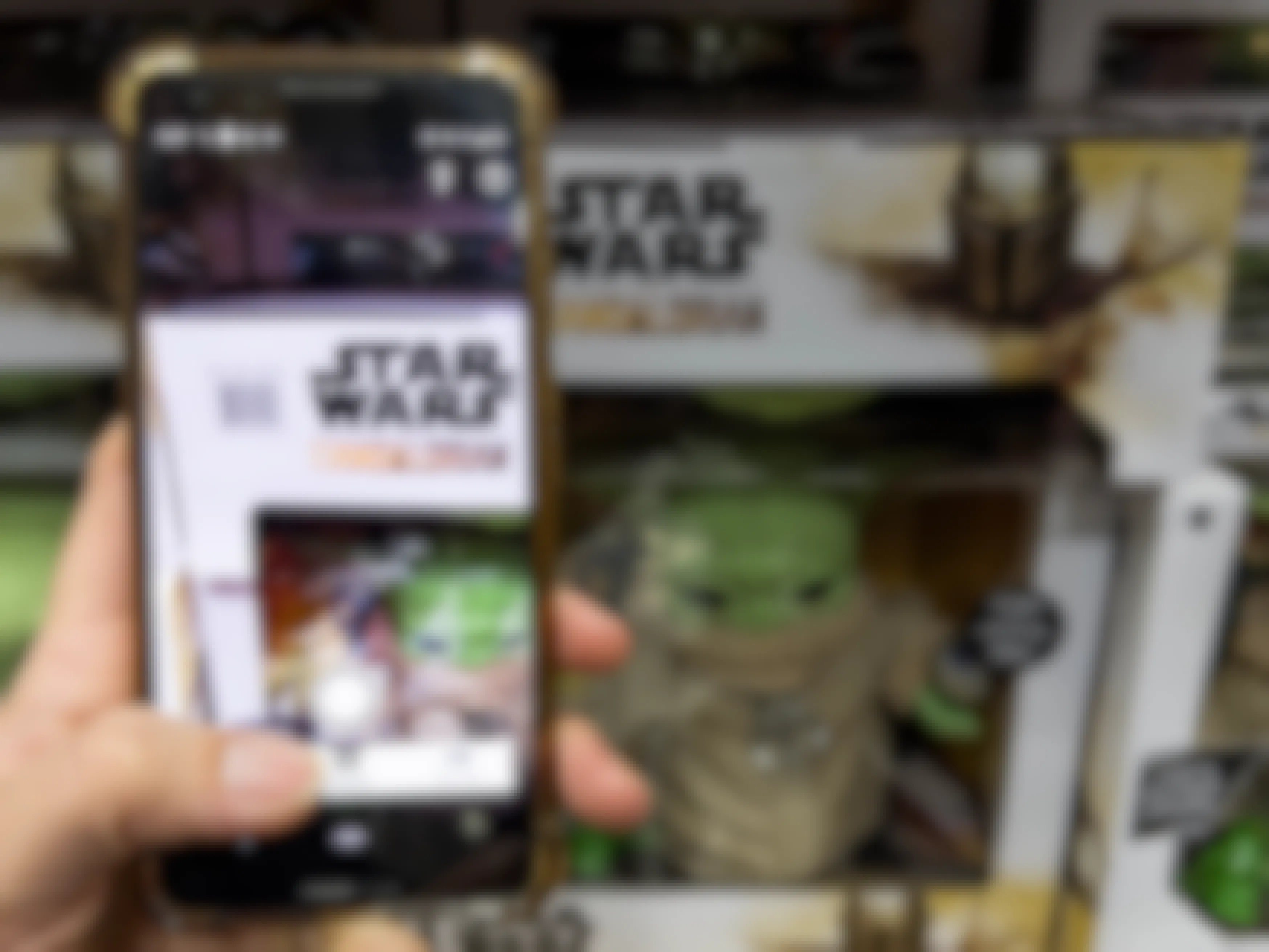 A person holding their phone, scanning a Star Wars Mandalorian toy with the Amazon mobile app.