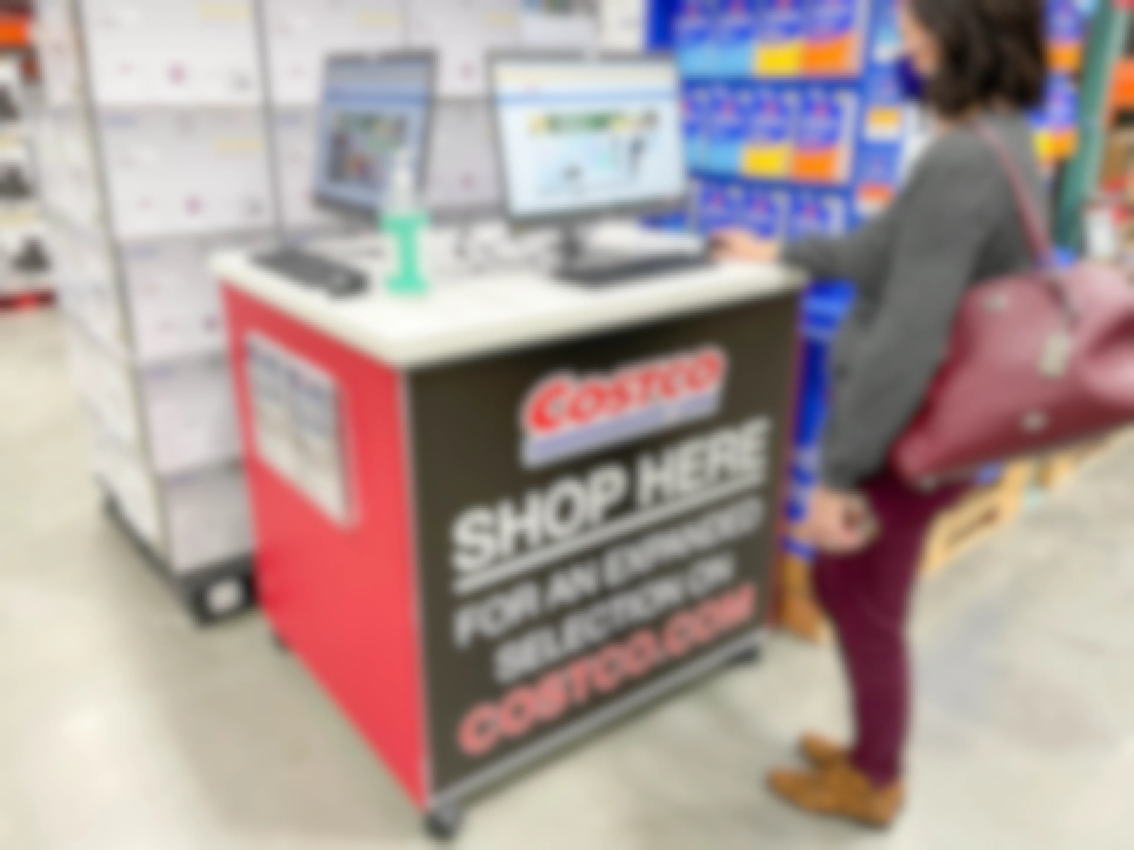 A woman standing at the Costco.com shop her Kiosk in store