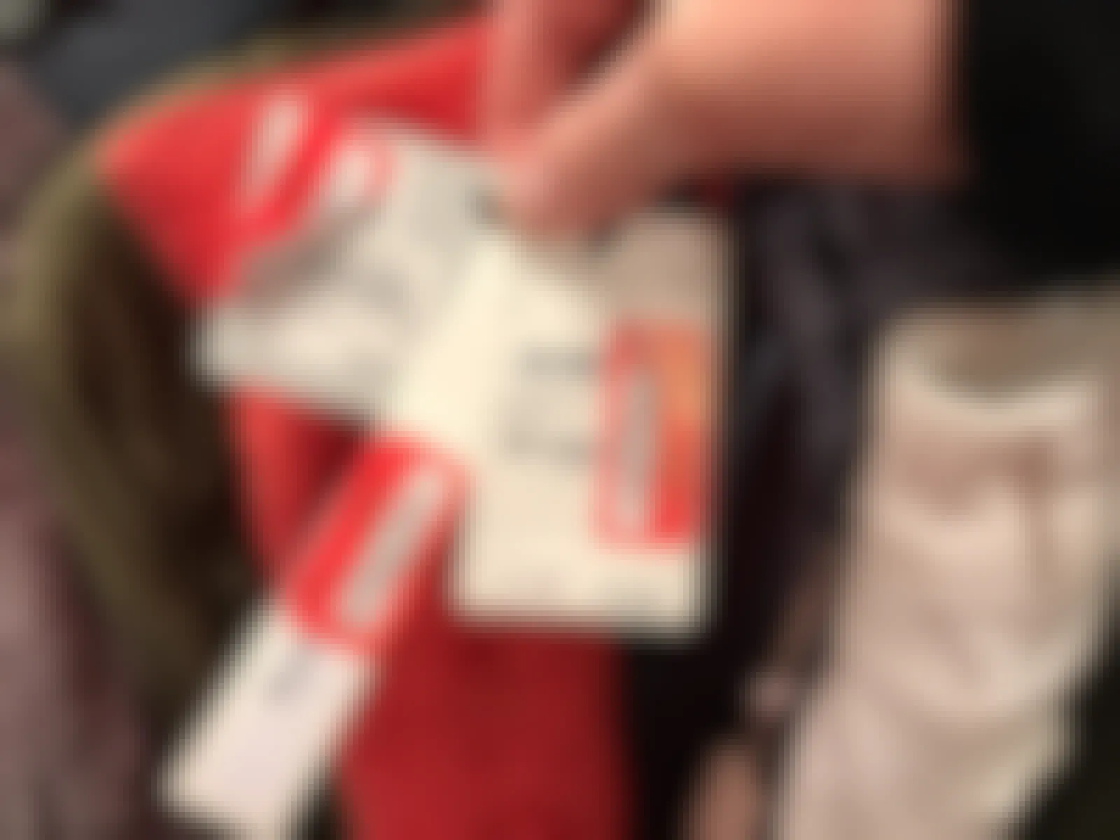 A person holding three price tags all with Nordstrom on the tag along with 3 red price tag stickers for Nordstrom Rack.
