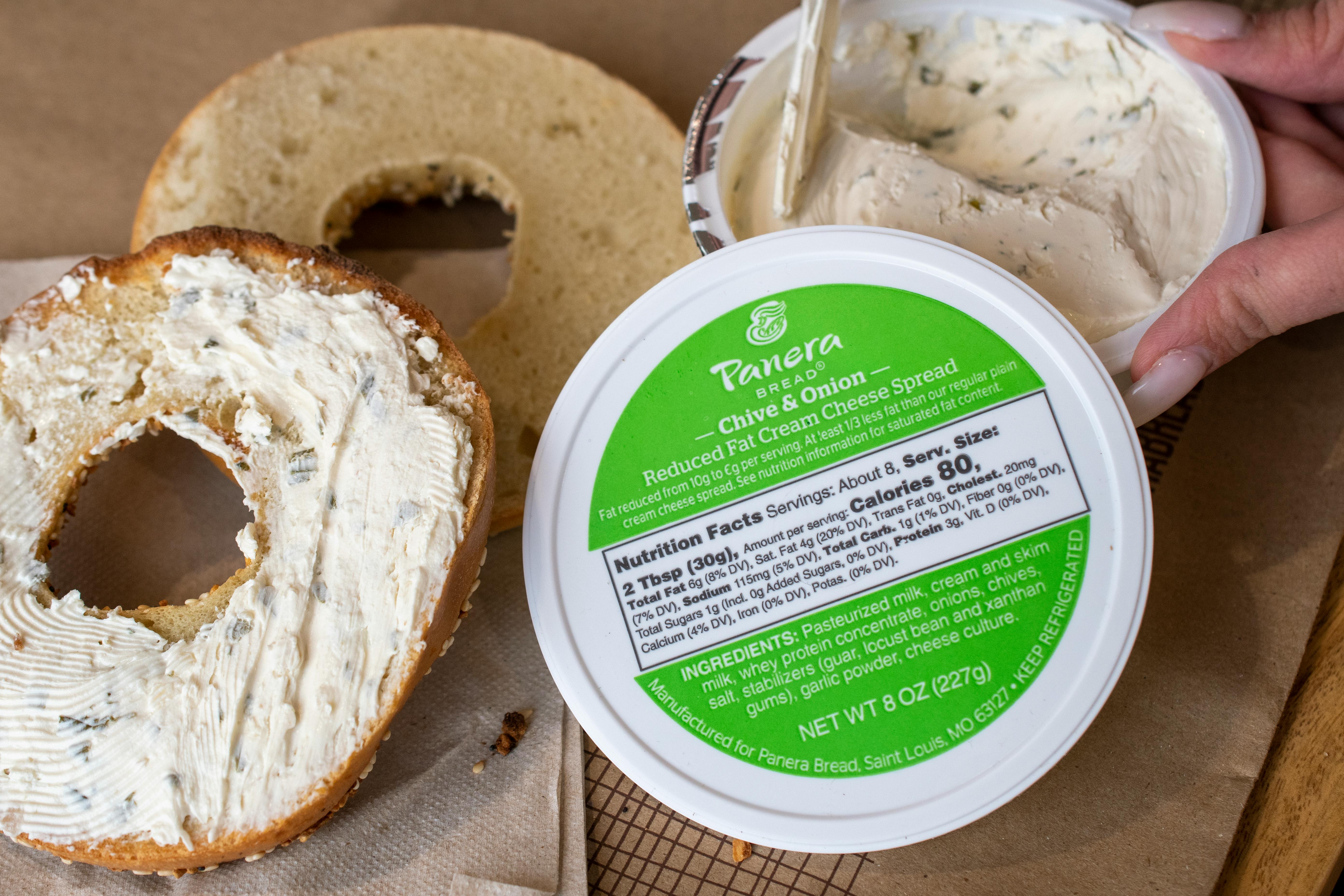 Panera cream cheese being spread on a bagel
