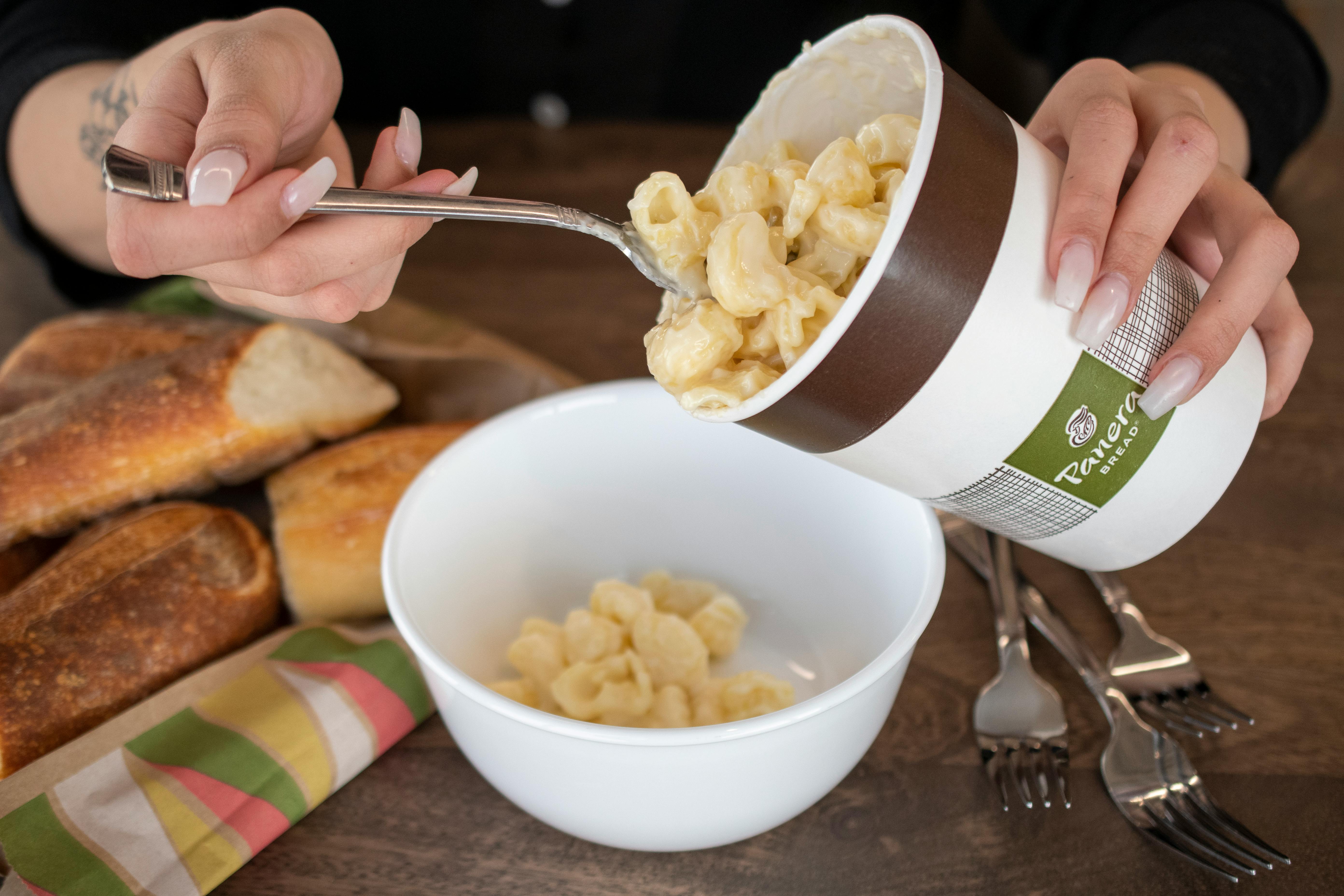 Mac n' cheese being poured into a bowl.