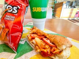 subway sub with chips and a drink