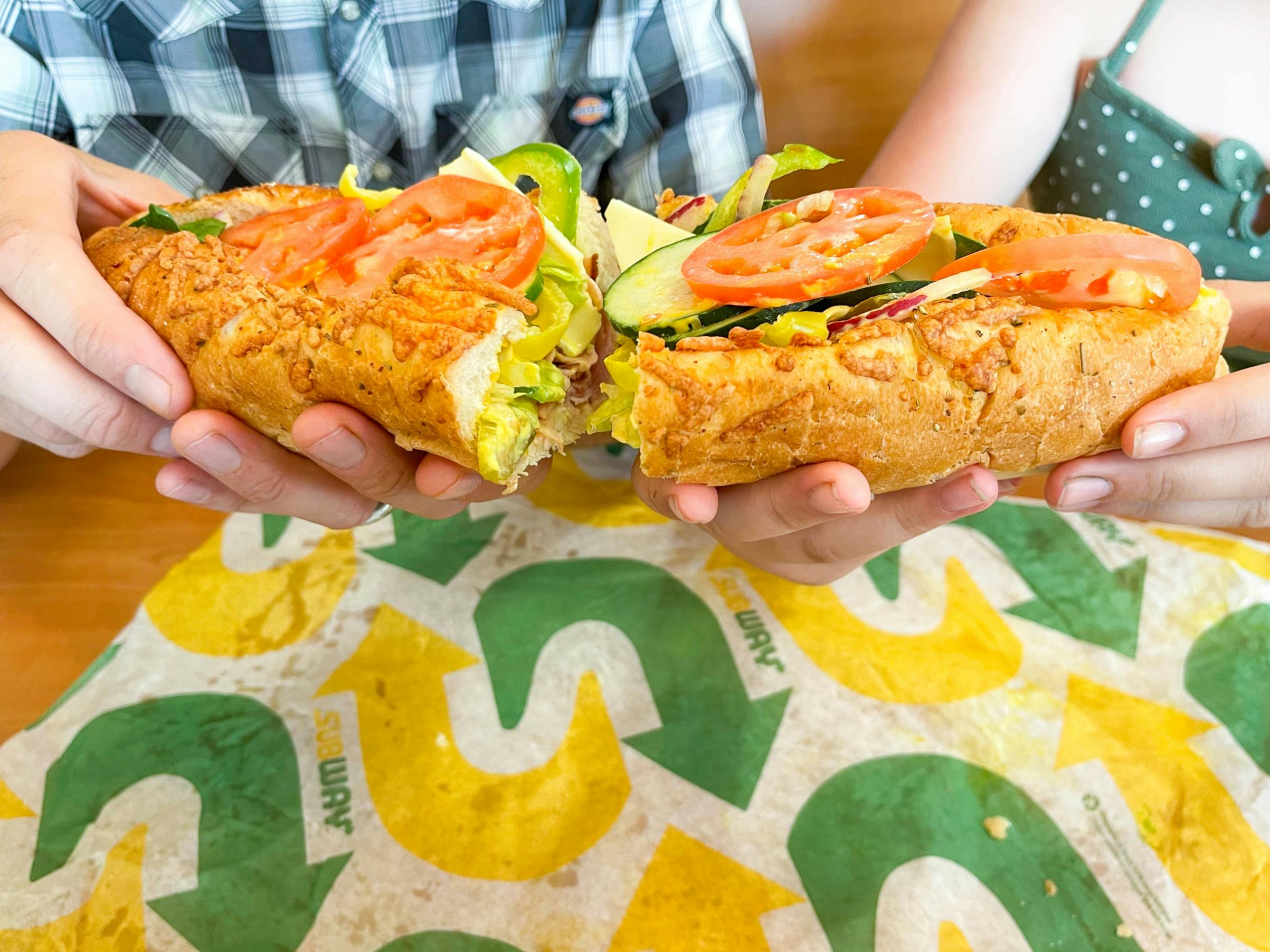 subway footlong with two people holding each half