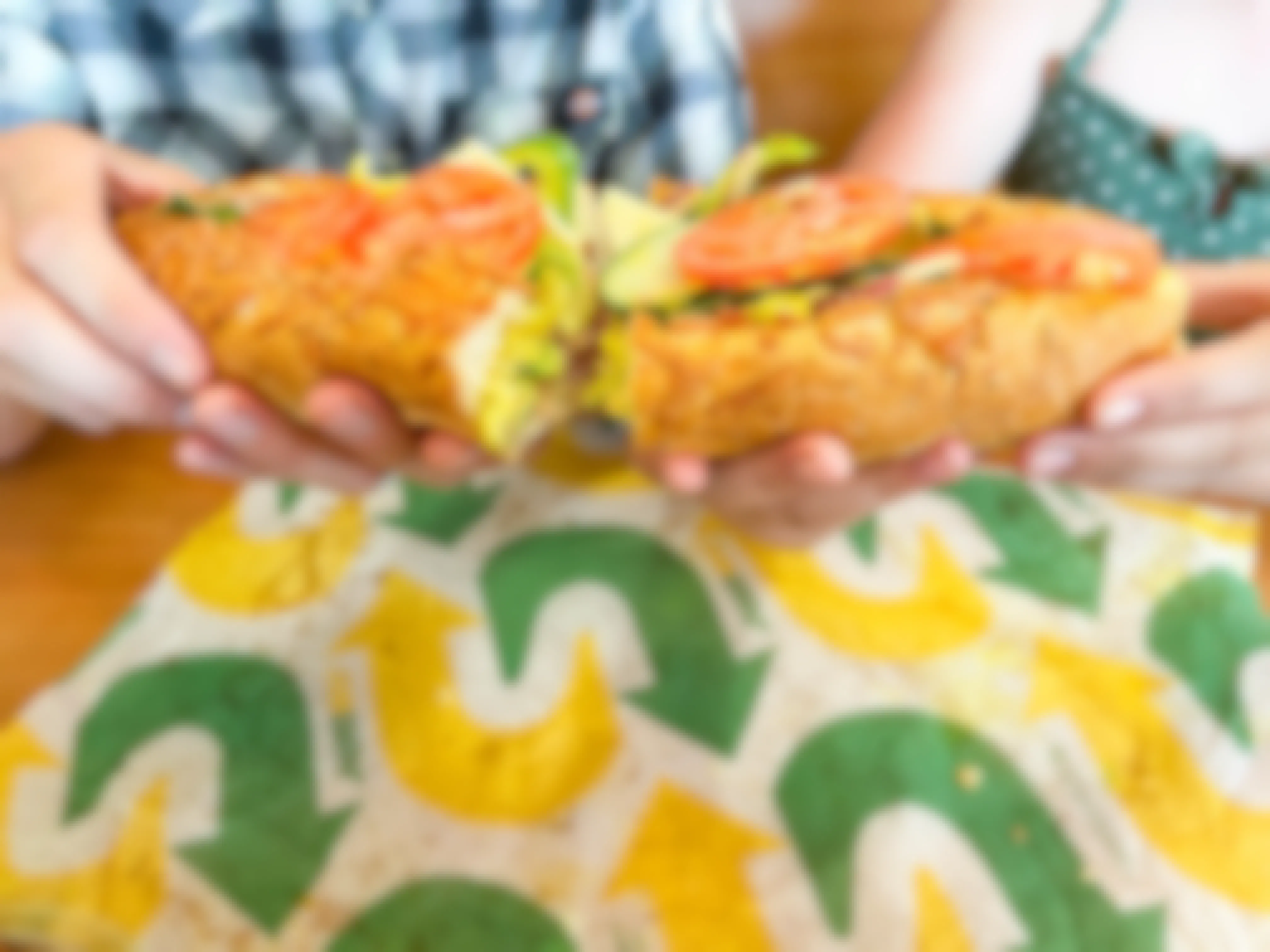 subway footlong with two people holding each half