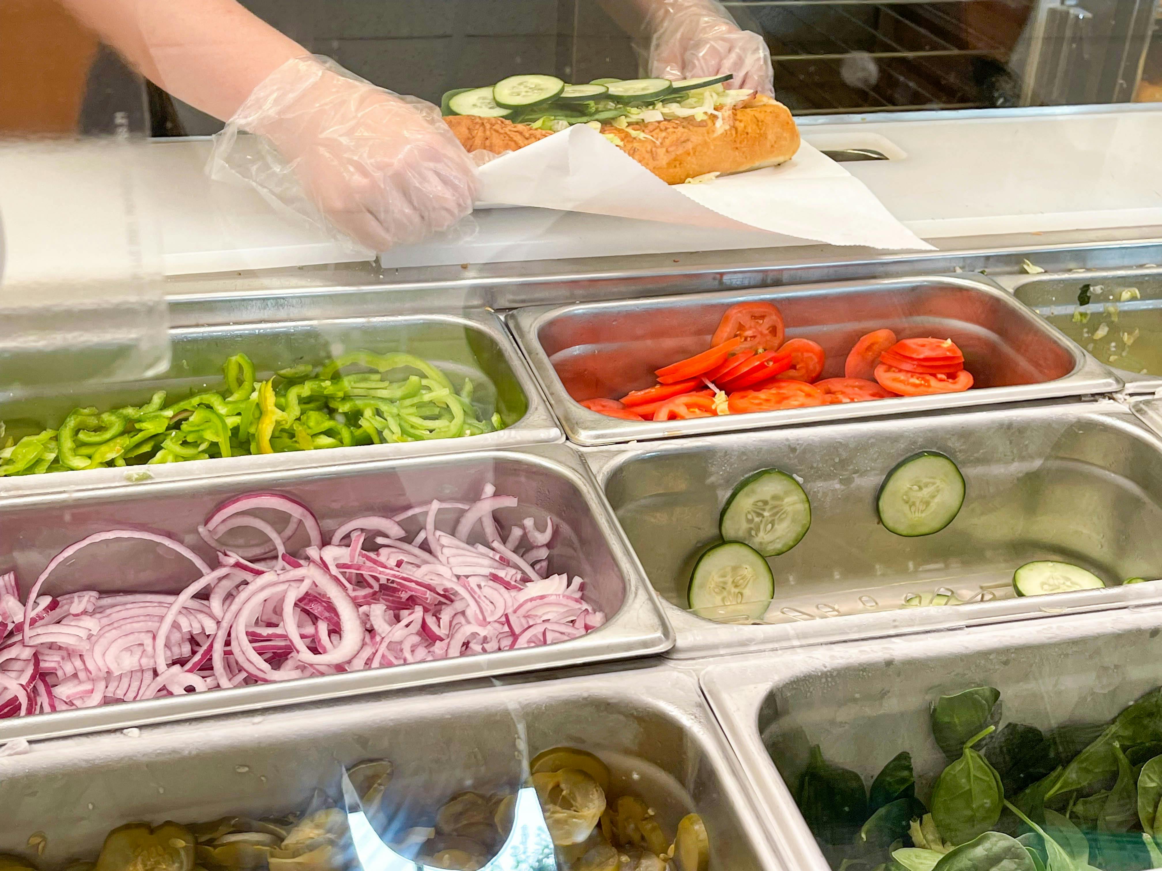 subway employee close up making sub